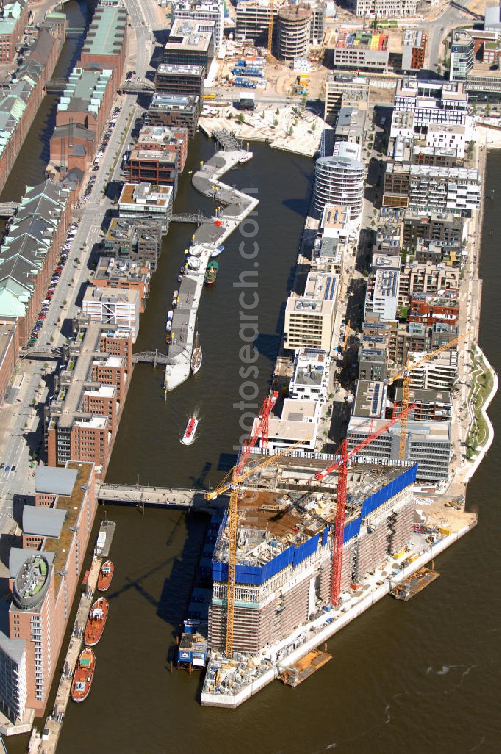 Hamburg from above - Blick auf die Baustelle der Elbphilharmonie auf dem Kaispeicher A der neu entstehenden Hafen City. Die HafenCity ist ein Hamburger Stadtteil im Bezirk Hamburg-Mitte. Der 155 Hektar große Stadtteil (mit 60 Hektar Nettobauland) soll neben Büroflächen für mehr als 40.000 Arbeitsplätze, die zu einem Teil schon fertiggestellt sind, auch Wohnraum für 12.000 Einwohner in 5.500 Wohnungen bieten und ist damit das größte laufende Vorhaben zur Stadtentwicklung von Hamburg. Allgemeine Informationen: