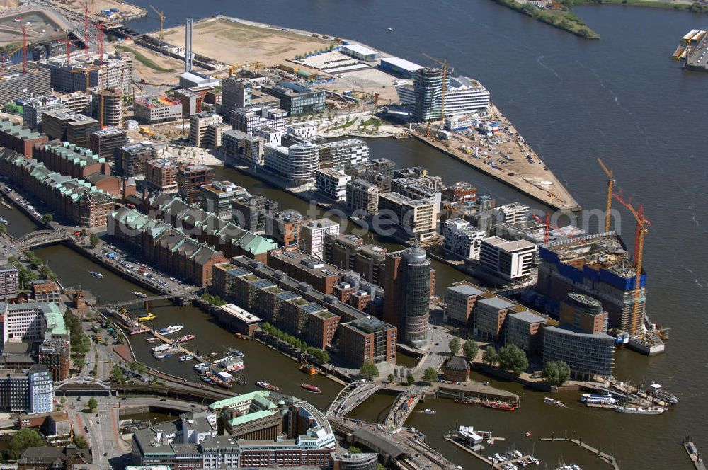 Hamburg from above - Blick über die Speicherstadt auf die Baustelle der neu entstehenden Hafen City mit Bauprojekten Am Sandtorkai, Dalmannkai, Am Sandtorpark, Strandkai und am Überseequartier. Die HafenCity ist ein Hamburger Stadtteil im Bezirk Hamburg-Mitte. Der 155 Hektar große Stadtteil (mit 60 Hektar Nettobauland) soll neben Büroflächen für mehr als 40.000 Arbeitsplätze, die zu einem Teil schon fertiggestellt sind, auch Wohnraum für 12.000 Einwohner in 5.500 Wohnungen bieten und ist damit das größte laufende Vorhaben zur Stadtentwicklung von Hamburg. Allgemeine Informationen: