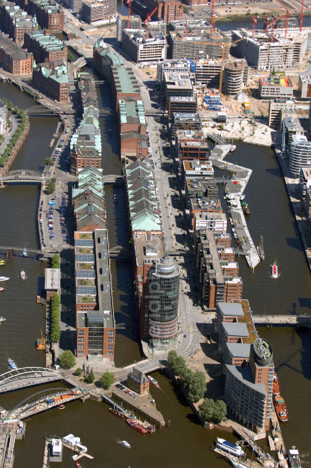 Aerial image Hamburg - Blick auf die Speicherstadt und die Baustelle der neu entstehenden Hafen City mit Bauprojekten Am Sandtorkai, Am Sandtorpark-Grasbrook, und am Überseequartier. Die HafenCity ist ein Hamburger Stadtteil im Bezirk Hamburg-Mitte. Der 155 Hektar große Stadtteil (mit 60 Hektar Nettobauland) soll neben Büroflächen für mehr als 40.000 Arbeitsplätze, die zu einem Teil schon fertiggestellt sind, auch Wohnraum für 12.000 Einwohner in 5.500 Wohnungen bieten und ist damit das größte laufende Vorhaben zur Stadtentwicklung von Hamburg. Allgemeine Informationen: