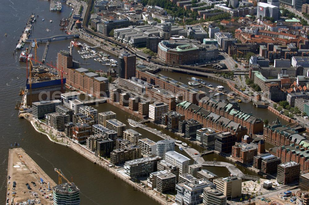 Aerial photograph Hamburg - Blick über die Baustelle der neu entstehenden Hafen City mit Bauprojekten am Dalmannkai und Am Sandtorkai auf die historische Speicherstadt. Die HafenCity ist ein Hamburger Stadtteil im Bezirk Hamburg-Mitte. Der 155 Hektar große Stadtteil (mit 60 Hektar Nettobauland) soll neben Büroflächen für mehr als 40.000 Arbeitsplätze, die zu einem Teil schon fertiggestellt sind, auch Wohnraum für 12.000 Einwohner in 5.500 Wohnungen bieten und ist damit das größte laufende Vorhaben zur Stadtentwicklung von Hamburg. Allgemeine Informationen: