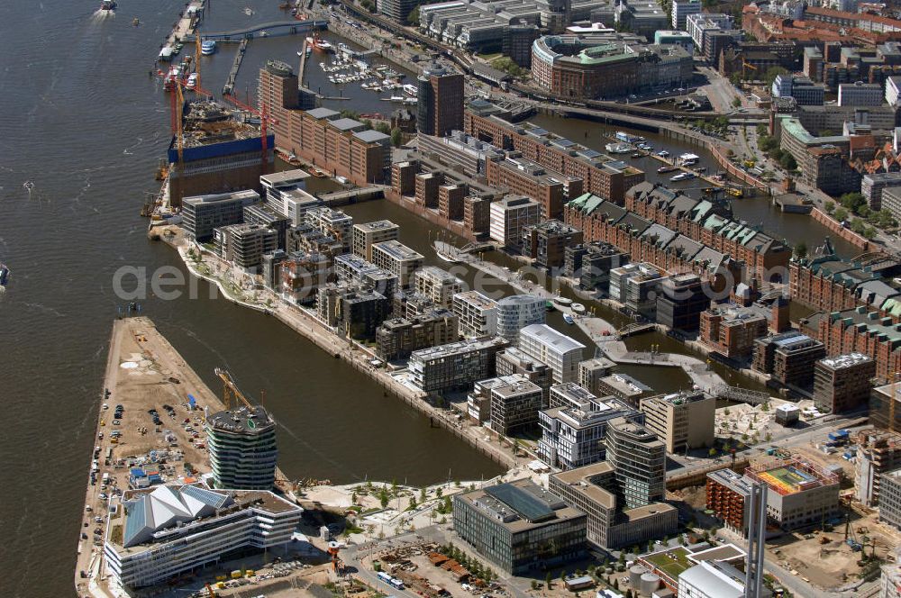 Hamburg from above - Blick über die Baustelle der neu entstehenden Hafen City mit Bauprojekten am Strandkai, am Sandtorpark-Grasbrook, am Dalmannkai und Am Sandtorkai auf die historische Speicherstadt. Die HafenCity ist ein Hamburger Stadtteil im Bezirk Hamburg-Mitte. Der 155 Hektar große Stadtteil (mit 60 Hektar Nettobauland) soll neben Büroflächen für mehr als 40.000 Arbeitsplätze, die zu einem Teil schon fertiggestellt sind, auch Wohnraum für 12.000 Einwohner in 5.500 Wohnungen bieten und ist damit das größte laufende Vorhaben zur Stadtentwicklung von Hamburg. Allgemeine Informationen: