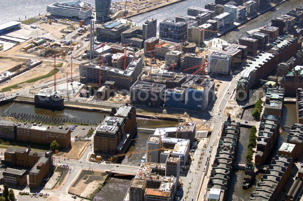 Hamburg from the bird's eye view: Blick auf die Baustelle der neu entstehenden Hafen City, mit Bauprojekten auf dem Brooktorkai, am Überseequartier, Strandkai und am Sandtorpark-Grasbrook. Die HafenCity ist ein Hamburger Stadtteil im Bezirk Hamburg-Mitte. Der 155 Hektar große Stadtteil (mit 60 Hektar Nettobauland) soll neben Büroflächen für mehr als 40.000 Arbeitsplätze, die zu einem Teil schon fertiggestellt sind, auch Wohnraum für 12.000 Einwohner in 5.500 Wohnungen bieten und ist damit das größte laufende Vorhaben zur Stadtentwicklung von Hamburg. Allgemeine Informationen: