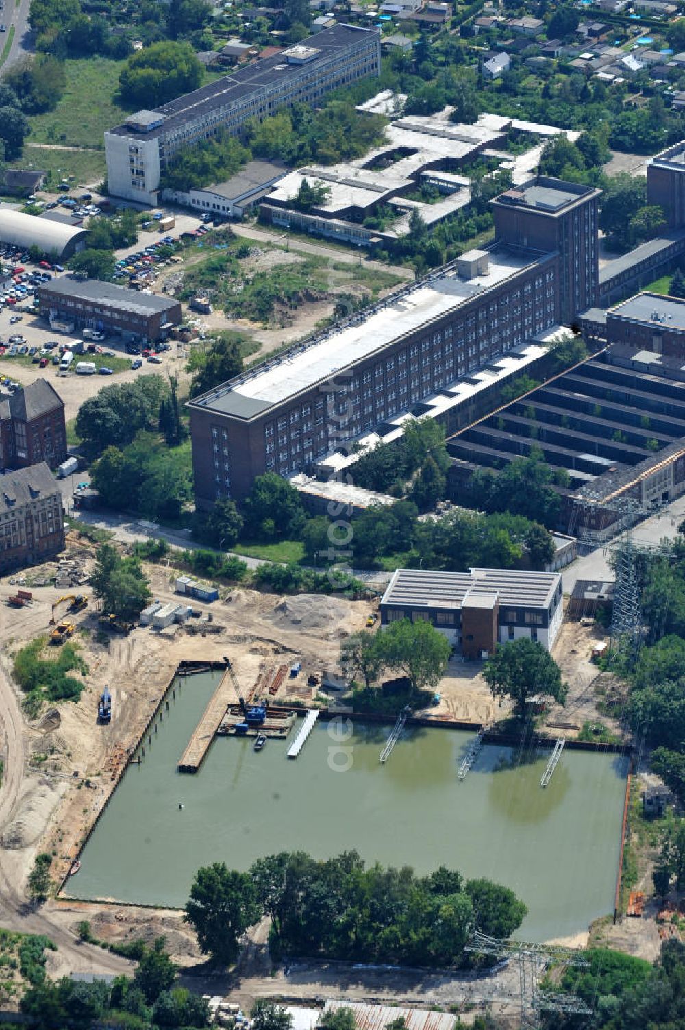 Berlin Schöneweide from the bird's eye view: Baustelle des Hafens der Reederei Riedel auf dem Gelände des ehemaligen Mineralöllagers an der Nalepastraße 10-16. Die traditionsreiche Reederei Riedel verlässt Kreuzberg und zieht auf das Teilgelände des ehemaligen DDR-Rundfunks an der Nalepastraße in Oberschöneweide. Umfangreiche Bodenaustausch- und Sanierungsarbeiten waren auf Grund hoher Bodenkontermination zuvor notwendig geworden. Site of the Port of Riedel in Berlin - Oberschöneweide.