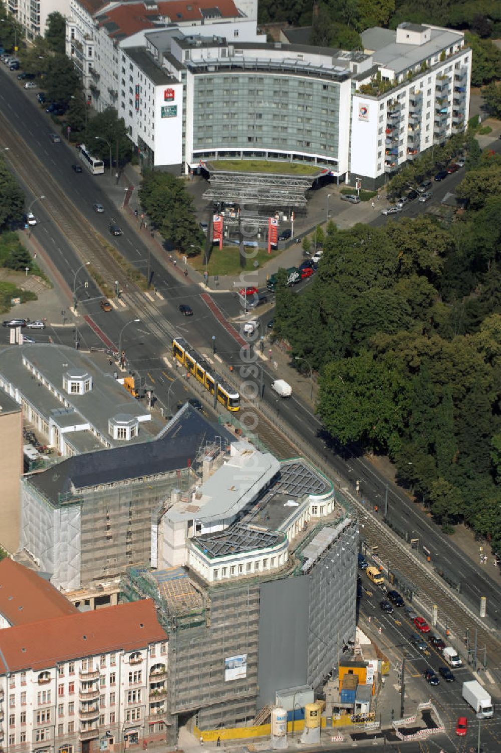 Aerial image Berlin - Blick auf die Baustelle am Haus der Einheit, dem ehemaligen Kaufhauses Jonaß, es hat in Berlin hat eine wechselvolle Geschichte hinter sich, die auch eng mit der jüngeren deutschen Geschichte verbunden ist. Auf dem Gelände eines 1828 errichteten Exerzier- und Reithauses baute der jüdische Kaufmann Hermann Golluber in den Jahren 1928/29 das sechsgeschossige Kaufhaus Kredit-Warenhaus Jonaß & Co AG. Das Gebäude in der damaligen Lothringer Straße 1 wurde von den Architekten Georg Bauer und Siegfried Friedländer in der Ende der 1920er Jahre aufkommenden Skelettbauweise im Stil der Neuen Sachlichkeit geplant und errichtet. Über einen zweigeschossigen mit Naturstein verkleideten Sockel schließt sich ein fünfgeschossiger Putzbau und ein Dachgeschoss an, in dem über einige Jahre ein Dachrestaurant betrieben wurde. Unmittelbar nach Ende des Zweiten Weltkrieges wurde das Gebäude verstaatlicht und Sitz des Zentralausschusses der SPD. Nach deren Vereinigung mit der KPD zur SED wurde es 1946 Sitz des Zentralkomitees der SED. Zwei in den Jahren 1976 und 1988 angebrachte Tafeln am Haupteingang des Gebäudes erinnern heute noch daran, dass der erste (und einzige) DDR-Präsident Wilhelm Pieck und sein Ministerpräsident Otto Grotewohl in dem Gebäude ihre Arbeitsräume hatten. In Hinblick auf den Zusammenschluss zwischen KPD und SPD erhielt es nun den Namen Haus der Einheit. Von 1956 bis 1990 war im Haus das Geschichtsinstitut beim ZK der SED ansässig, zu dem auch das historische Archiv der KPD und das Zentrale Parteiarchiv der SED gehörten. Das seit 1995 leer stehende Haus wurde nach langwierigen Verhandlungen mit den Vertretern der in aller Welt verstreuten jüdischen Erben im Januar an einen britischen Investor verkauft. Dieser hat das Berliner Architektur-Büro JSK mit der Umbauplanung des markanten, teilweise unter Denkmalschutz stehenden Gebäudes beauftragt.