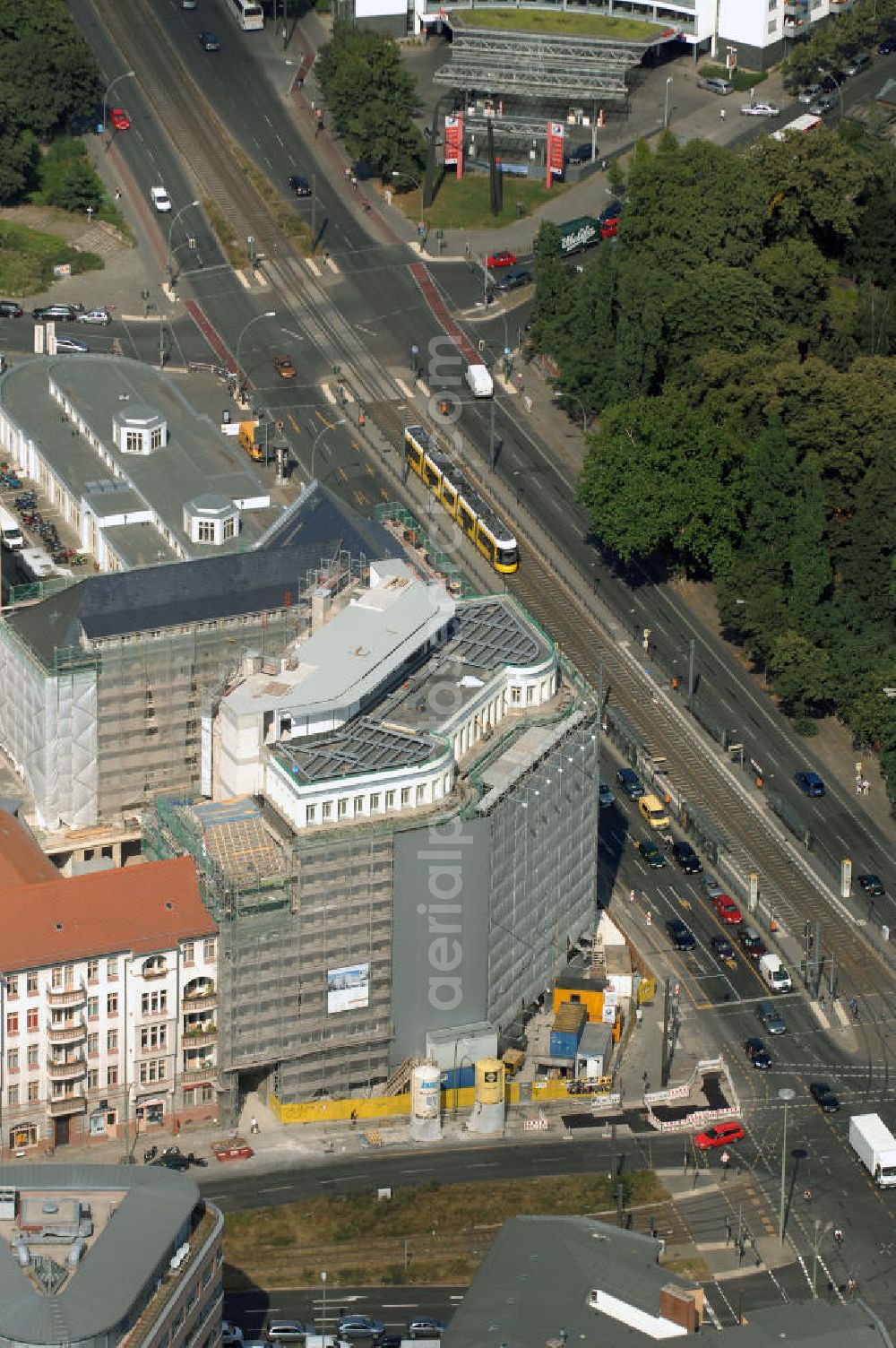 Aerial photograph Berlin - Blick auf die Baustelle am Haus der Einheit, dem ehemaligen Kaufhauses Jonaß, es hat in Berlin hat eine wechselvolle Geschichte hinter sich, die auch eng mit der jüngeren deutschen Geschichte verbunden ist. Auf dem Gelände eines 1828 errichteten Exerzier- und Reithauses baute der jüdische Kaufmann Hermann Golluber in den Jahren 1928/29 das sechsgeschossige Kaufhaus Kredit-Warenhaus Jonaß & Co AG. Das Gebäude in der damaligen Lothringer Straße 1 wurde von den Architekten Georg Bauer und Siegfried Friedländer in der Ende der 1920er Jahre aufkommenden Skelettbauweise im Stil der Neuen Sachlichkeit geplant und errichtet. Über einen zweigeschossigen mit Naturstein verkleideten Sockel schließt sich ein fünfgeschossiger Putzbau und ein Dachgeschoss an, in dem über einige Jahre ein Dachrestaurant betrieben wurde. Unmittelbar nach Ende des Zweiten Weltkrieges wurde das Gebäude verstaatlicht und Sitz des Zentralausschusses der SPD. Nach deren Vereinigung mit der KPD zur SED wurde es 1946 Sitz des Zentralkomitees der SED. Zwei in den Jahren 1976 und 1988 angebrachte Tafeln am Haupteingang des Gebäudes erinnern heute noch daran, dass der erste (und einzige) DDR-Präsident Wilhelm Pieck und sein Ministerpräsident Otto Grotewohl in dem Gebäude ihre Arbeitsräume hatten. In Hinblick auf den Zusammenschluss zwischen KPD und SPD erhielt es nun den Namen Haus der Einheit. Von 1956 bis 1990 war im Haus das Geschichtsinstitut beim ZK der SED ansässig, zu dem auch das historische Archiv der KPD und das Zentrale Parteiarchiv der SED gehörten. Das seit 1995 leer stehende Haus wurde nach langwierigen Verhandlungen mit den Vertretern der in aller Welt verstreuten jüdischen Erben im Januar an einen britischen Investor verkauft. Dieser hat das Berliner Architektur-Büro JSK mit der Umbauplanung des markanten, teilweise unter Denkmalschutz stehenden Gebäudes beauftragt.