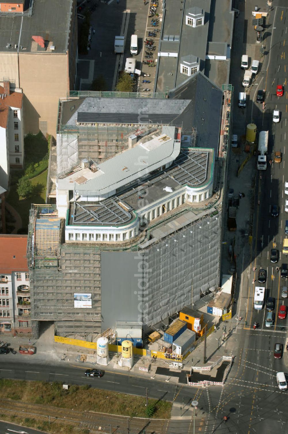 Berlin from the bird's eye view: Blick auf die Baustelle am Haus der Einheit, dem ehemaligen Kaufhauses Jonaß, es hat in Berlin hat eine wechselvolle Geschichte hinter sich, die auch eng mit der jüngeren deutschen Geschichte verbunden ist. Auf dem Gelände eines 1828 errichteten Exerzier- und Reithauses baute der jüdische Kaufmann Hermann Golluber in den Jahren 1928/29 das sechsgeschossige Kaufhaus Kredit-Warenhaus Jonaß & Co AG. Das Gebäude in der damaligen Lothringer Straße 1 wurde von den Architekten Georg Bauer und Siegfried Friedländer in der Ende der 1920er Jahre aufkommenden Skelettbauweise im Stil der Neuen Sachlichkeit geplant und errichtet. Über einen zweigeschossigen mit Naturstein verkleideten Sockel schließt sich ein fünfgeschossiger Putzbau und ein Dachgeschoss an, in dem über einige Jahre ein Dachrestaurant betrieben wurde. Unmittelbar nach Ende des Zweiten Weltkrieges wurde das Gebäude verstaatlicht und Sitz des Zentralausschusses der SPD. Nach deren Vereinigung mit der KPD zur SED wurde es 1946 Sitz des Zentralkomitees der SED. Zwei in den Jahren 1976 und 1988 angebrachte Tafeln am Haupteingang des Gebäudes erinnern heute noch daran, dass der erste (und einzige) DDR-Präsident Wilhelm Pieck und sein Ministerpräsident Otto Grotewohl in dem Gebäude ihre Arbeitsräume hatten. In Hinblick auf den Zusammenschluss zwischen KPD und SPD erhielt es nun den Namen Haus der Einheit. Von 1956 bis 1990 war im Haus das Geschichtsinstitut beim ZK der SED ansässig, zu dem auch das historische Archiv der KPD und das Zentrale Parteiarchiv der SED gehörten. Das seit 1995 leer stehende Haus wurde nach langwierigen Verhandlungen mit den Vertretern der in aller Welt verstreuten jüdischen Erben im Januar an einen britischen Investor verkauft. Dieser hat das Berliner Architektur-Büro JSK mit der Umbauplanung des markanten, teilweise unter Denkmalschutz stehenden Gebäudes beauftragt.