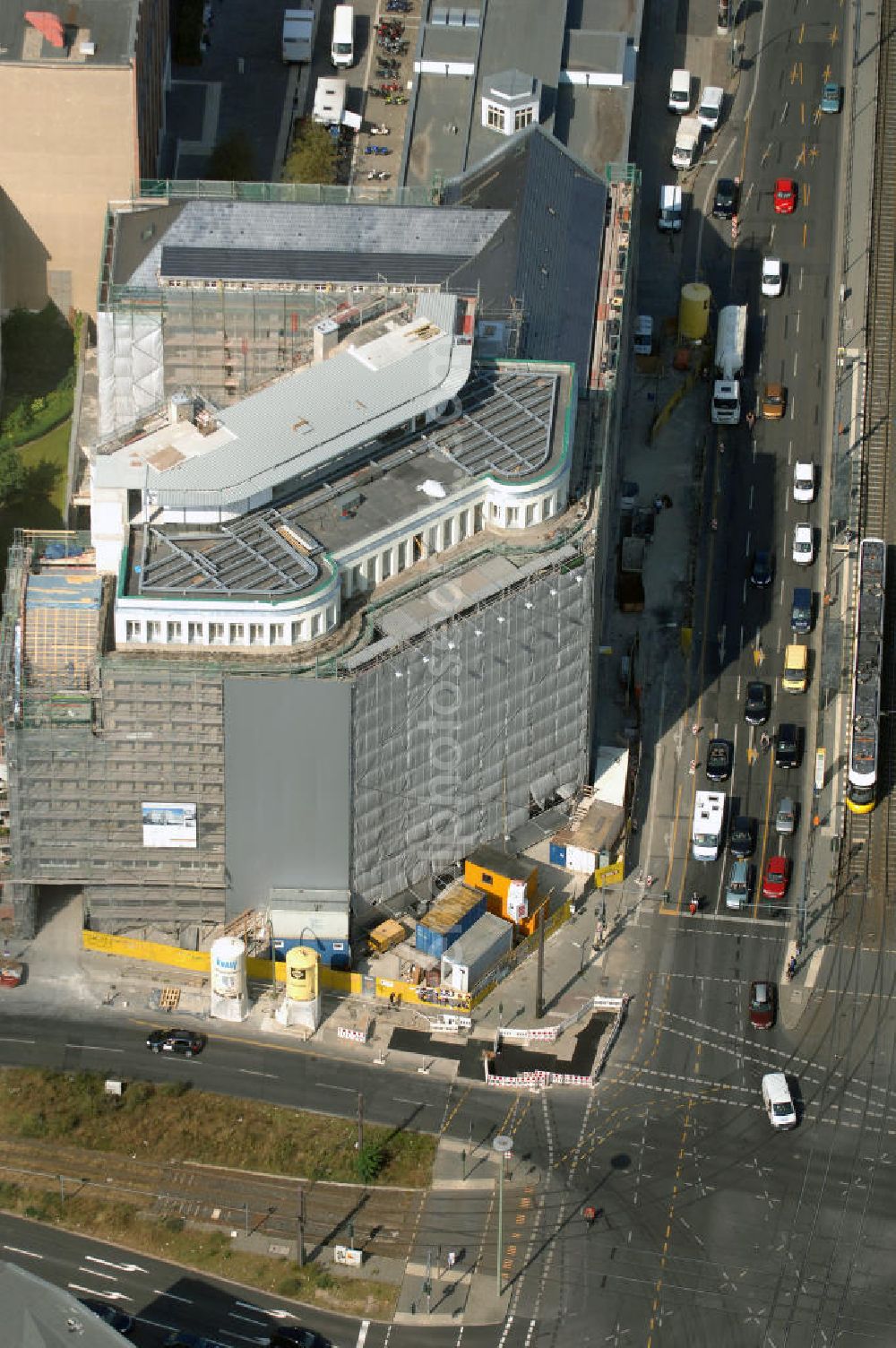 Berlin from above - Blick auf die Baustelle am Haus der Einheit, dem ehemaligen Kaufhauses Jonaß, es hat in Berlin hat eine wechselvolle Geschichte hinter sich, die auch eng mit der jüngeren deutschen Geschichte verbunden ist. Auf dem Gelände eines 1828 errichteten Exerzier- und Reithauses baute der jüdische Kaufmann Hermann Golluber in den Jahren 1928/29 das sechsgeschossige Kaufhaus Kredit-Warenhaus Jonaß & Co AG. Das Gebäude in der damaligen Lothringer Straße 1 wurde von den Architekten Georg Bauer und Siegfried Friedländer in der Ende der 1920er Jahre aufkommenden Skelettbauweise im Stil der Neuen Sachlichkeit geplant und errichtet. Über einen zweigeschossigen mit Naturstein verkleideten Sockel schließt sich ein fünfgeschossiger Putzbau und ein Dachgeschoss an, in dem über einige Jahre ein Dachrestaurant betrieben wurde. Unmittelbar nach Ende des Zweiten Weltkrieges wurde das Gebäude verstaatlicht und Sitz des Zentralausschusses der SPD. Nach deren Vereinigung mit der KPD zur SED wurde es 1946 Sitz des Zentralkomitees der SED. Zwei in den Jahren 1976 und 1988 angebrachte Tafeln am Haupteingang des Gebäudes erinnern heute noch daran, dass der erste (und einzige) DDR-Präsident Wilhelm Pieck und sein Ministerpräsident Otto Grotewohl in dem Gebäude ihre Arbeitsräume hatten. In Hinblick auf den Zusammenschluss zwischen KPD und SPD erhielt es nun den Namen Haus der Einheit. Von 1956 bis 1990 war im Haus das Geschichtsinstitut beim ZK der SED ansässig, zu dem auch das historische Archiv der KPD und das Zentrale Parteiarchiv der SED gehörten. Das seit 1995 leer stehende Haus wurde nach langwierigen Verhandlungen mit den Vertretern der in aller Welt verstreuten jüdischen Erben im Januar an einen britischen Investor verkauft. Dieser hat das Berliner Architektur-Büro JSK mit der Umbauplanung des markanten, teilweise unter Denkmalschutz stehenden Gebäudes beauftragt.