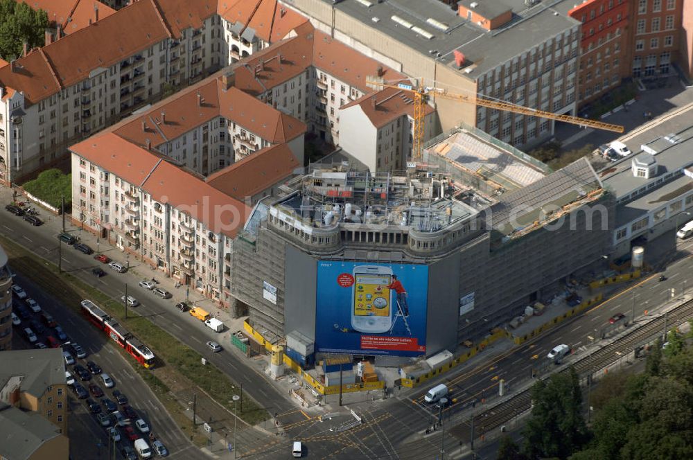 Berlin from above - Blick auf die Baustelle am Haus der Einheit, dem ehemaligen Kaufhauses Jonaß, es hat in Berlin hat eine wechselvolle Geschichte hinter sich, die auch eng mit der jüngeren deutschen Geschichte verbunden ist. Auf dem Gelände eines 1828 errichteten Exerzier- und Reithauses baute der jüdische Kaufmann Hermann Golluber in den Jahren 1928/29 das sechsgeschossige Kaufhaus Kredit-Warenhaus Jonaß & Co AG. Das Gebäude in der damaligen Lothringer Straße 1 wurde von den Architekten Georg Bauer und Siegfried Friedländer in der Ende der 1920er Jahre aufkommenden Skelettbauweise im Stil der Neuen Sachlichkeit geplant und errichtet. Über einen zweigeschossigen mit Naturstein verkleideten Sockel schließt sich ein fünfgeschossiger Putzbau und ein Dachgeschoss an, in dem über einige Jahre ein Dachrestaurant betrieben wurde. Unmittelbar nach Ende des Zweiten Weltkrieges wurde das Gebäude verstaatlicht und Sitz des Zentralausschusses der SPD. Nach deren Vereinigung mit der KPD zur SED wurde es 1946 Sitz des Zentralkomitees der SED. Zwei in den Jahren 1976 und 1988 angebrachte Tafeln am Haupteingang des Gebäudes erinnern heute noch daran, dass der erste (und einzige) DDR-Präsident Wilhelm Pieck und sein Ministerpräsident Otto Grotewohl in dem Gebäude ihre Arbeitsräume hatten. In Hinblick auf den Zusammenschluss zwischen KPD und SPD erhielt es nun den Namen Haus der Einheit. Von 1956 bis 1990 war im Haus das Geschichtsinstitut beim ZK der SED ansässig, zu dem auch das historische Archiv der KPD und das Zentrale Parteiarchiv der SED gehörten. Das seit 1995 leer stehende Haus wurde nach langwierigen Verhandlungen mit den Vertretern der in aller Welt verstreuten jüdischen Erben im Januar an einen britischen Investor verkauft. Dieser hat das Berliner Architektur-Büro JSK mit der Umbauplanung des markanten, teilweise unter Denkmalschutz stehenden Gebäudes beauftragt.