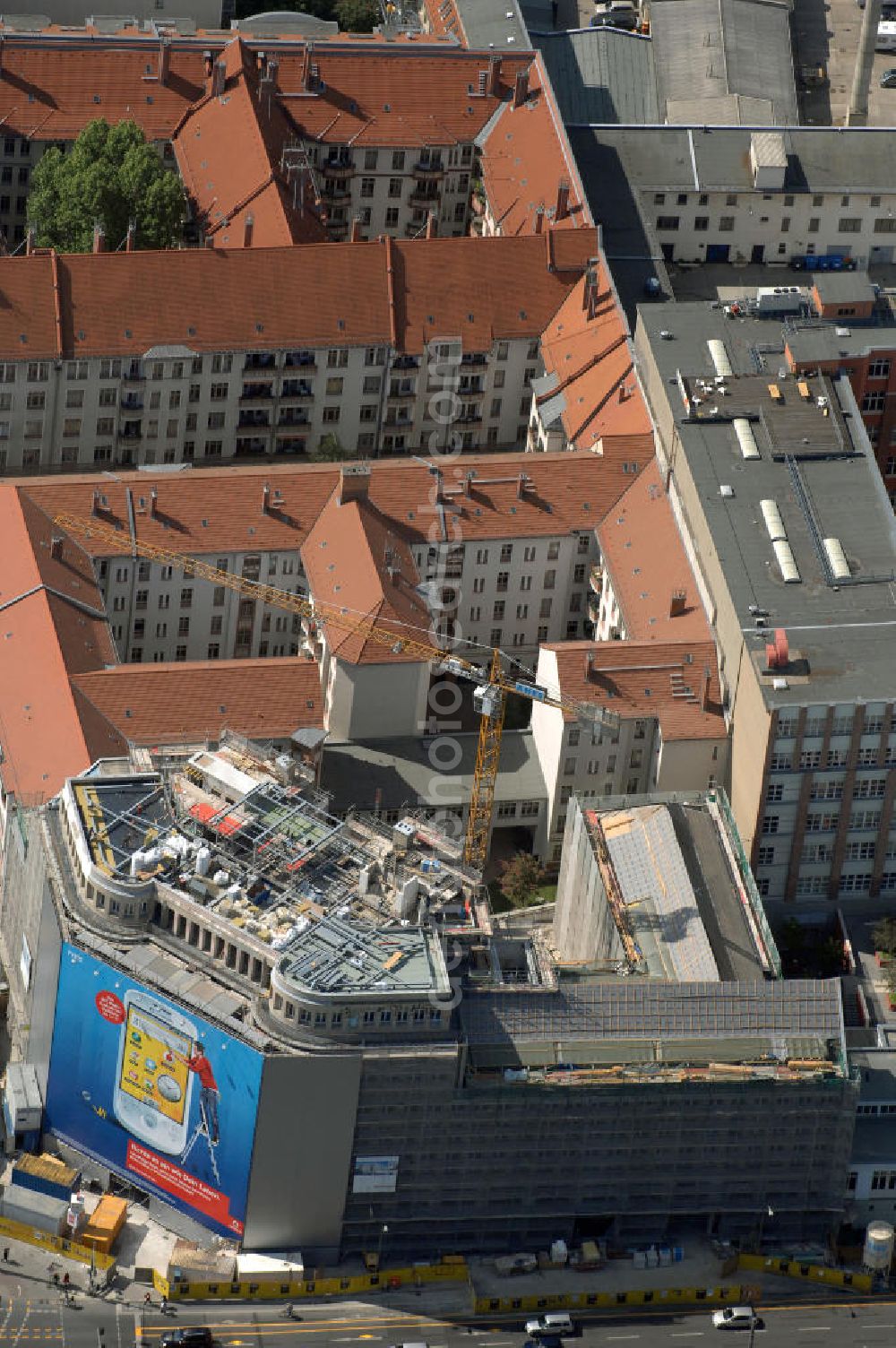 Berlin from the bird's eye view: Blick auf die Baustelle am Haus der Einheit, dem ehemaligen Kaufhauses Jonaß, es hat in Berlin hat eine wechselvolle Geschichte hinter sich, die auch eng mit der jüngeren deutschen Geschichte verbunden ist. Auf dem Gelände eines 1828 errichteten Exerzier- und Reithauses baute der jüdische Kaufmann Hermann Golluber in den Jahren 1928/29 das sechsgeschossige Kaufhaus Kredit-Warenhaus Jonaß & Co AG. Das Gebäude in der damaligen Lothringer Straße 1 wurde von den Architekten Georg Bauer und Siegfried Friedländer in der Ende der 1920er Jahre aufkommenden Skelettbauweise im Stil der Neuen Sachlichkeit geplant und errichtet. Über einen zweigeschossigen mit Naturstein verkleideten Sockel schließt sich ein fünfgeschossiger Putzbau und ein Dachgeschoss an, in dem über einige Jahre ein Dachrestaurant betrieben wurde. Unmittelbar nach Ende des Zweiten Weltkrieges wurde das Gebäude verstaatlicht und Sitz des Zentralausschusses der SPD. Nach deren Vereinigung mit der KPD zur SED wurde es 1946 Sitz des Zentralkomitees der SED. Zwei in den Jahren 1976 und 1988 angebrachte Tafeln am Haupteingang des Gebäudes erinnern heute noch daran, dass der erste (und einzige) DDR-Präsident Wilhelm Pieck und sein Ministerpräsident Otto Grotewohl in dem Gebäude ihre Arbeitsräume hatten. In Hinblick auf den Zusammenschluss zwischen KPD und SPD erhielt es nun den Namen Haus der Einheit. Von 1956 bis 1990 war im Haus das Geschichtsinstitut beim ZK der SED ansässig, zu dem auch das historische Archiv der KPD und das Zentrale Parteiarchiv der SED gehörten. Das seit 1995 leer stehende Haus wurde nach langwierigen Verhandlungen mit den Vertretern der in aller Welt verstreuten jüdischen Erben im Januar an einen britischen Investor verkauft. Dieser hat das Berliner Architektur-Büro JSK mit der Umbauplanung des markanten, teilweise unter Denkmalschutz stehenden Gebäudes beauftragt.