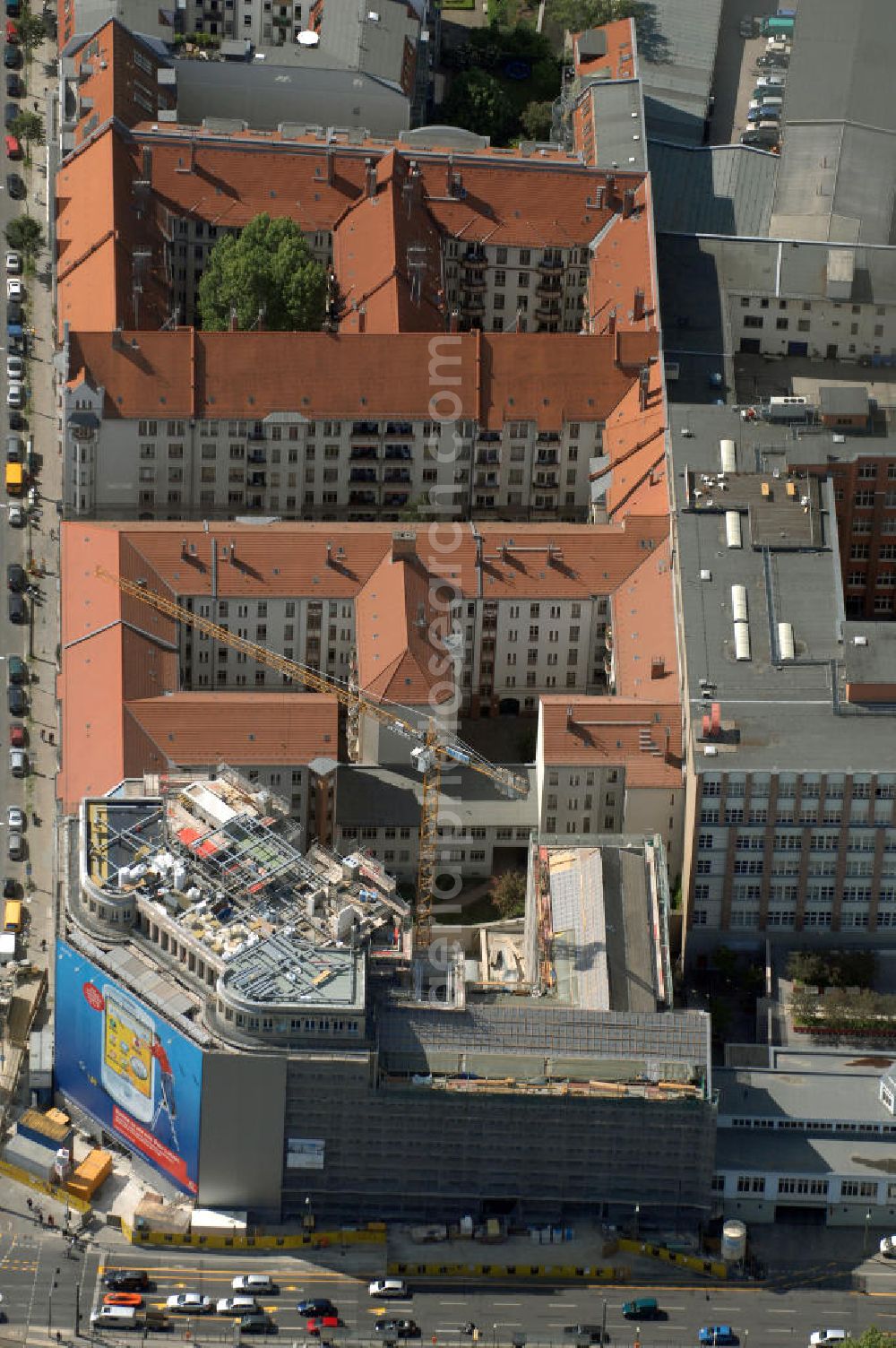 Aerial image Berlin - Blick auf die Baustelle am Haus der Einheit, dem ehemaligen Kaufhauses Jonaß, es hat in Berlin hat eine wechselvolle Geschichte hinter sich, die auch eng mit der jüngeren deutschen Geschichte verbunden ist. Auf dem Gelände eines 1828 errichteten Exerzier- und Reithauses baute der jüdische Kaufmann Hermann Golluber in den Jahren 1928/29 das sechsgeschossige Kaufhaus Kredit-Warenhaus Jonaß & Co AG. Das Gebäude in der damaligen Lothringer Straße 1 wurde von den Architekten Georg Bauer und Siegfried Friedländer in der Ende der 1920er Jahre aufkommenden Skelettbauweise im Stil der Neuen Sachlichkeit geplant und errichtet. Über einen zweigeschossigen mit Naturstein verkleideten Sockel schließt sich ein fünfgeschossiger Putzbau und ein Dachgeschoss an, in dem über einige Jahre ein Dachrestaurant betrieben wurde. Unmittelbar nach Ende des Zweiten Weltkrieges wurde das Gebäude verstaatlicht und Sitz des Zentralausschusses der SPD. Nach deren Vereinigung mit der KPD zur SED wurde es 1946 Sitz des Zentralkomitees der SED. Zwei in den Jahren 1976 und 1988 angebrachte Tafeln am Haupteingang des Gebäudes erinnern heute noch daran, dass der erste (und einzige) DDR-Präsident Wilhelm Pieck und sein Ministerpräsident Otto Grotewohl in dem Gebäude ihre Arbeitsräume hatten. In Hinblick auf den Zusammenschluss zwischen KPD und SPD erhielt es nun den Namen Haus der Einheit. Von 1956 bis 1990 war im Haus das Geschichtsinstitut beim ZK der SED ansässig, zu dem auch das historische Archiv der KPD und das Zentrale Parteiarchiv der SED gehörten. Das seit 1995 leer stehende Haus wurde nach langwierigen Verhandlungen mit den Vertretern der in aller Welt verstreuten jüdischen Erben im Januar an einen britischen Investor verkauft. Dieser hat das Berliner Architektur-Büro JSK mit der Umbauplanung des markanten, teilweise unter Denkmalschutz stehenden Gebäudes beauftragt.