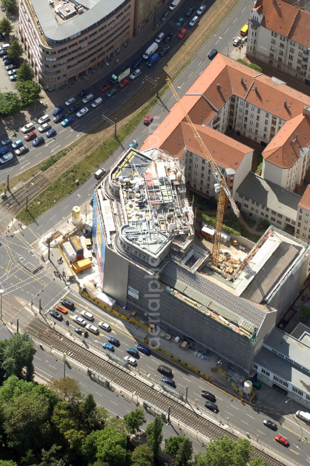 Aerial photograph Berlin - Blick auf die Baustelle am Haus der Einheit, dem ehemaligen Kaufhauses Jonaß, es hat in Berlin hat eine wechselvolle Geschichte hinter sich, die auch eng mit der jüngeren deutschen Geschichte verbunden ist. Auf dem Gelände eines 1828 errichteten Exerzier- und Reithauses baute der jüdische Kaufmann Hermann Golluber in den Jahren 1928/29 das sechsgeschossige Kaufhaus Kredit-Warenhaus Jonaß & Co AG. Das Gebäude in der damaligen Lothringer Straße 1 wurde von den Architekten Georg Bauer und Siegfried Friedländer in der Ende der 1920er Jahre aufkommenden Skelettbauweise im Stil der Neuen Sachlichkeit geplant und errichtet. Über einen zweigeschossigen mit Naturstein verkleideten Sockel schließt sich ein fünfgeschossiger Putzbau und ein Dachgeschoss an, in dem über einige Jahre ein Dachrestaurant betrieben wurde. Unmittelbar nach Ende des Zweiten Weltkrieges wurde das Gebäude verstaatlicht und Sitz des Zentralausschusses der SPD. Nach deren Vereinigung mit der KPD zur SED wurde es 1946 Sitz des Zentralkomitees der SED. Zwei in den Jahren 1976 und 1988 angebrachte Tafeln am Haupteingang des Gebäudes erinnern heute noch daran, dass der erste (und einzige) DDR-Präsident Wilhelm Pieck und sein Ministerpräsident Otto Grotewohl in dem Gebäude ihre Arbeitsräume hatten. In Hinblick auf den Zusammenschluss zwischen KPD und SPD erhielt es nun den Namen Haus der Einheit. Von 1956 bis 1990 war im Haus das Geschichtsinstitut beim ZK der SED ansässig, zu dem auch das historische Archiv der KPD und das Zentrale Parteiarchiv der SED gehörten. Das seit 1995 leer stehende Haus wurde nach langwierigen Verhandlungen mit den Vertretern der in aller Welt verstreuten jüdischen Erben im Januar an einen britischen Investor verkauft. Dieser hat das Berliner Architektur-Büro JSK mit der Umbauplanung des markanten, teilweise unter Denkmalschutz stehenden Gebäudes beauftragt.