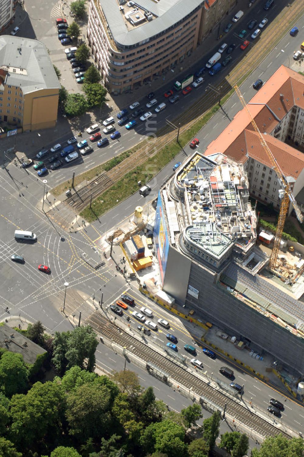 Aerial photograph Berlin - Blick auf die Baustelle am Haus der Einheit, dem ehemaligen Kaufhauses Jonaß, es hat in Berlin hat eine wechselvolle Geschichte hinter sich, die auch eng mit der jüngeren deutschen Geschichte verbunden ist. Auf dem Gelände eines 1828 errichteten Exerzier- und Reithauses baute der jüdische Kaufmann Hermann Golluber in den Jahren 1928/29 das sechsgeschossige Kaufhaus Kredit-Warenhaus Jonaß & Co AG. Das Gebäude in der damaligen Lothringer Straße 1 wurde von den Architekten Georg Bauer und Siegfried Friedländer in der Ende der 1920er Jahre aufkommenden Skelettbauweise im Stil der Neuen Sachlichkeit geplant und errichtet. Über einen zweigeschossigen mit Naturstein verkleideten Sockel schließt sich ein fünfgeschossiger Putzbau und ein Dachgeschoss an, in dem über einige Jahre ein Dachrestaurant betrieben wurde. Unmittelbar nach Ende des Zweiten Weltkrieges wurde das Gebäude verstaatlicht und Sitz des Zentralausschusses der SPD. Nach deren Vereinigung mit der KPD zur SED wurde es 1946 Sitz des Zentralkomitees der SED. Zwei in den Jahren 1976 und 1988 angebrachte Tafeln am Haupteingang des Gebäudes erinnern heute noch daran, dass der erste (und einzige) DDR-Präsident Wilhelm Pieck und sein Ministerpräsident Otto Grotewohl in dem Gebäude ihre Arbeitsräume hatten. In Hinblick auf den Zusammenschluss zwischen KPD und SPD erhielt es nun den Namen Haus der Einheit. Von 1956 bis 1990 war im Haus das Geschichtsinstitut beim ZK der SED ansässig, zu dem auch das historische Archiv der KPD und das Zentrale Parteiarchiv der SED gehörten. Das seit 1995 leer stehende Haus wurde nach langwierigen Verhandlungen mit den Vertretern der in aller Welt verstreuten jüdischen Erben im Januar an einen britischen Investor verkauft. Dieser hat das Berliner Architektur-Büro JSK mit der Umbauplanung des markanten, teilweise unter Denkmalschutz stehenden Gebäudes beauftragt.