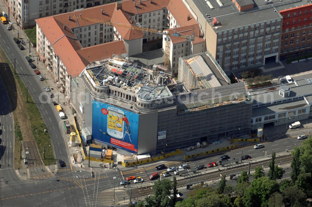 Berlin from above - Blick auf die Baustelle am Haus der Einheit, dem ehemaligen Kaufhauses Jonaß, es hat in Berlin hat eine wechselvolle Geschichte hinter sich, die auch eng mit der jüngeren deutschen Geschichte verbunden ist. Auf dem Gelände eines 1828 errichteten Exerzier- und Reithauses baute der jüdische Kaufmann Hermann Golluber in den Jahren 1928/29 das sechsgeschossige Kaufhaus Kredit-Warenhaus Jonaß & Co AG. Das Gebäude in der damaligen Lothringer Straße 1 wurde von den Architekten Georg Bauer und Siegfried Friedländer in der Ende der 1920er Jahre aufkommenden Skelettbauweise im Stil der Neuen Sachlichkeit geplant und errichtet. Über einen zweigeschossigen mit Naturstein verkleideten Sockel schließt sich ein fünfgeschossiger Putzbau und ein Dachgeschoss an, in dem über einige Jahre ein Dachrestaurant betrieben wurde. Unmittelbar nach Ende des Zweiten Weltkrieges wurde das Gebäude verstaatlicht und Sitz des Zentralausschusses der SPD. Nach deren Vereinigung mit der KPD zur SED wurde es 1946 Sitz des Zentralkomitees der SED. Zwei in den Jahren 1976 und 1988 angebrachte Tafeln am Haupteingang des Gebäudes erinnern heute noch daran, dass der erste (und einzige) DDR-Präsident Wilhelm Pieck und sein Ministerpräsident Otto Grotewohl in dem Gebäude ihre Arbeitsräume hatten. In Hinblick auf den Zusammenschluss zwischen KPD und SPD erhielt es nun den Namen Haus der Einheit. Von 1956 bis 1990 war im Haus das Geschichtsinstitut beim ZK der SED ansässig, zu dem auch das historische Archiv der KPD und das Zentrale Parteiarchiv der SED gehörten. Das seit 1995 leer stehende Haus wurde nach langwierigen Verhandlungen mit den Vertretern der in aller Welt verstreuten jüdischen Erben im Januar an einen britischen Investor verkauft. Dieser hat das Berliner Architektur-Büro JSK mit der Umbauplanung des markanten, teilweise unter Denkmalschutz stehenden Gebäudes beauftragt.