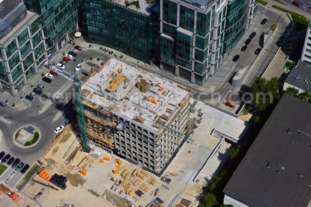 Aerial photograph Warschau - Construction site behind the office building complex New City in the district of Mokotow in Warsaw in Poland. A new building is created next to a small roundabout. The site used to be a parking lot. The building will be adjacent to New City