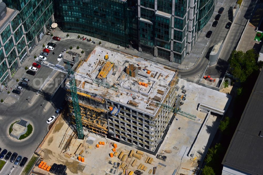 Warschau from the bird's eye view: Construction site behind the office building complex New City in the district of Mokotow in Warsaw in Poland. A new building is created next to a small roundabout. The site used to be a parking lot. The building will be adjacent to New City