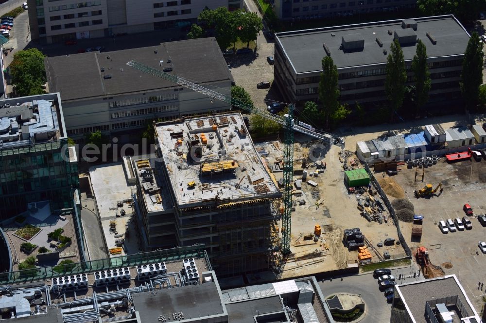 Warschau from the bird's eye view: Construction site behind the office building complex New City in the district of Mokotow in Warsaw in Poland. A new building is created next to a small roundabout. The site used to be a parking lot. The building will be adjacent to New City