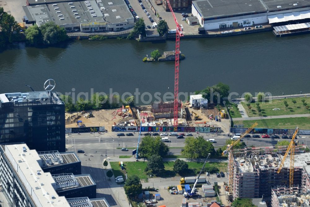 Aerial photograph Berlin - Construction site of Project Living Levels at Muhlenstrasse on the banks of the River Spree in Berlin - Friedrichshain. On the grounds of the Berlin Wall border strip at the EastSideGallery, the company Living Bauhaus is building a futuristic high-rise residential. The real estate service company City & Home GmbH manages the available apartments