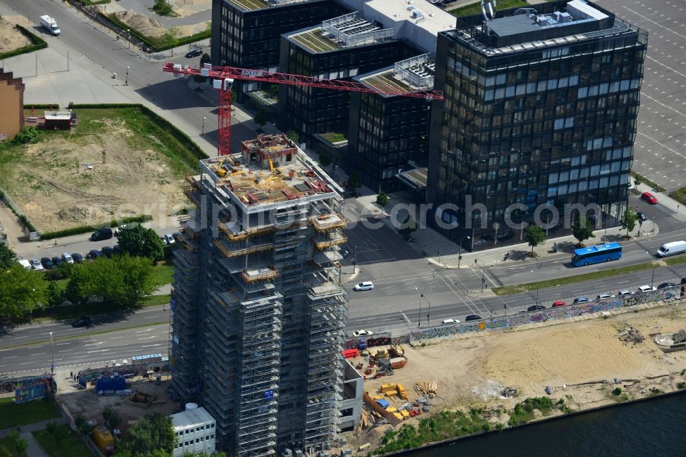 Berlin from the bird's eye view: Construction site of Project Living Levels at Muhlenstrasse on the banks of the River Spree in Berlin - Friedrichshain. On the grounds of the Berlin Wall border strip at the EastSideGallery, the company Living Bauhaus is building a futuristic high-rise residential. The real estate service company City & Home GmbH manages the available apartments