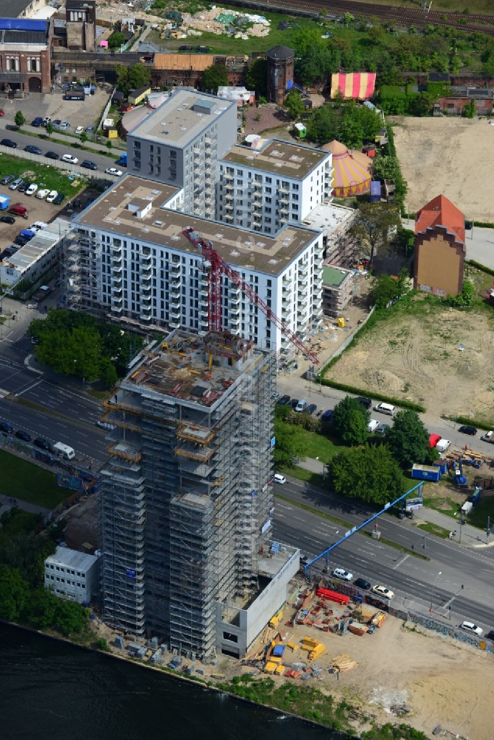 Berlin from the bird's eye view: Construction site of Project Living Levels at Muhlenstrasse on the banks of the River Spree in Berlin - Friedrichshain. On the grounds of the Berlin Wall border strip at the EastSideGallery, the company Living Bauhaus is building a futuristic high-rise residential. The real estate service company City & Home GmbH manages the available apartments