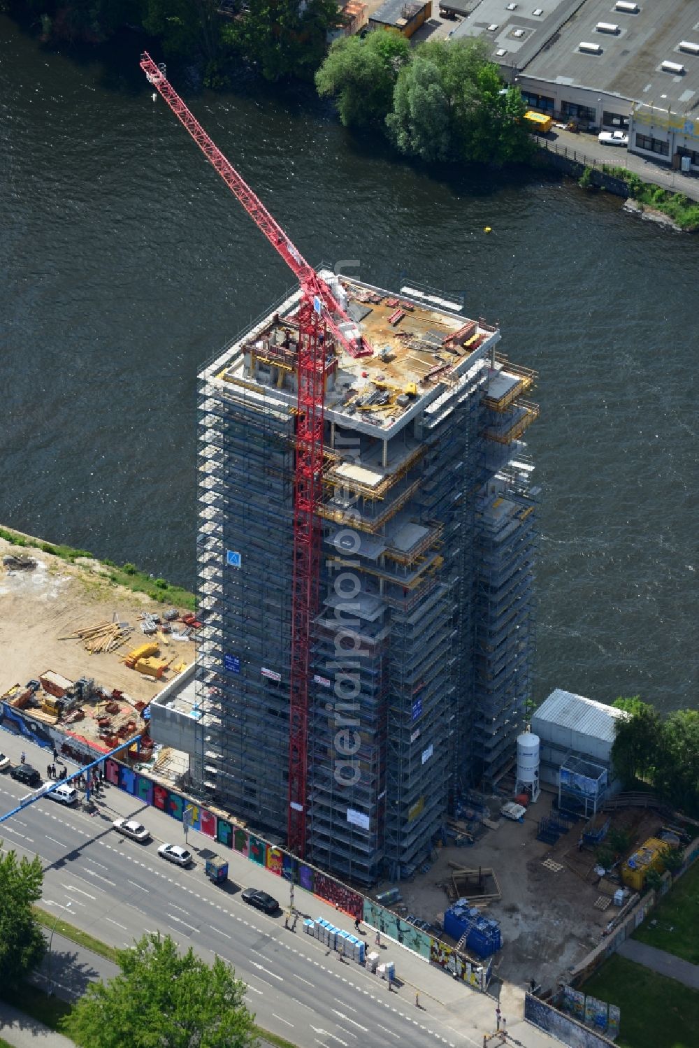 Aerial photograph Berlin - Construction site of Project Living Levels at Muhlenstrasse on the banks of the River Spree in Berlin - Friedrichshain. On the grounds of the Berlin Wall border strip at the EastSideGallery, the company Living Bauhaus is building a futuristic high-rise residential. The real estate service company City & Home GmbH manages the available apartments