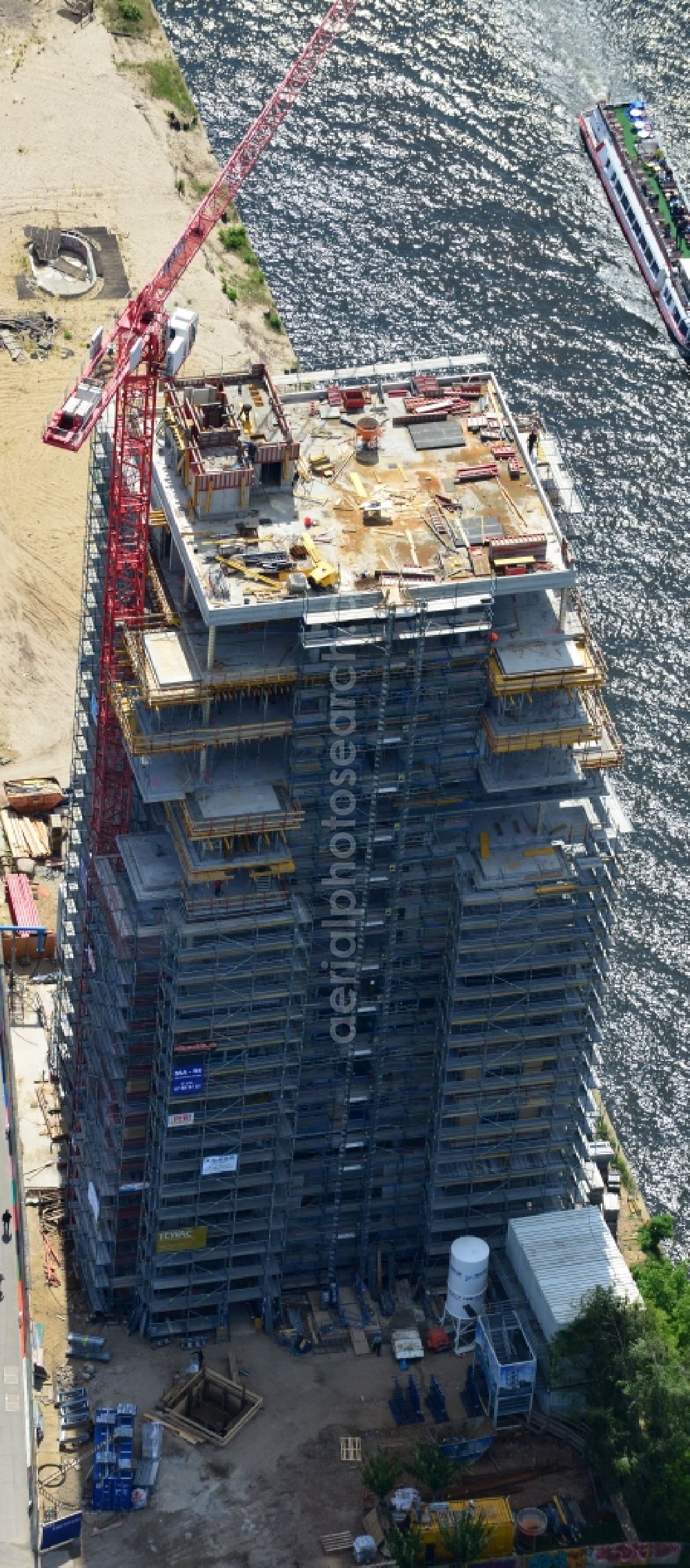 Aerial photograph Berlin - Construction site of Project Living Levels at Muhlenstrasse on the banks of the River Spree in Berlin - Friedrichshain. On the grounds of the Berlin Wall border strip at the EastSideGallery, the company Living Bauhaus is building a futuristic high-rise residential. The real estate service company City & Home GmbH manages the available apartments