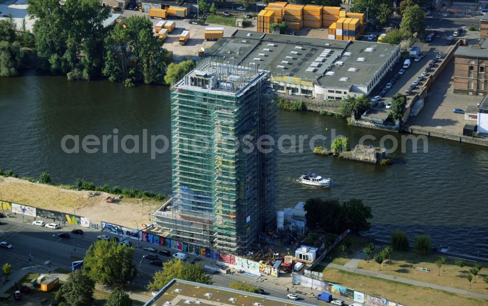 Berlin from the bird's eye view: Construction site of Project Living Levels at Muhlenstrasse on the banks of the River Spree in Berlin - Friedrichshain. On the grounds of the Berlin Wall border strip at the EastSideGallery, the company Living Bauhaus is building a futuristic high-rise residential. The real estate service company City & Home GmbH manages the available apartments