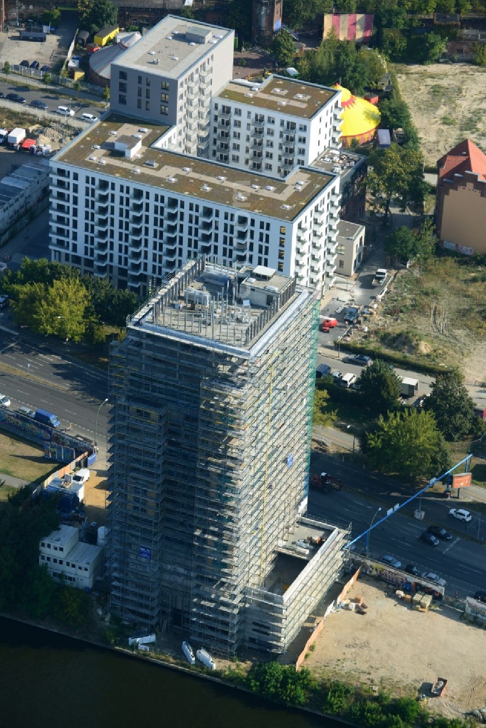 Berlin from the bird's eye view: Construction site of Project Living Levels at Muhlenstrasse on the banks of the River Spree in Berlin - Friedrichshain. On the grounds of the Berlin Wall border strip at the EastSideGallery, the company Living Bauhaus is building a futuristic high-rise residential. The real estate service company City & Home GmbH manages the available apartments