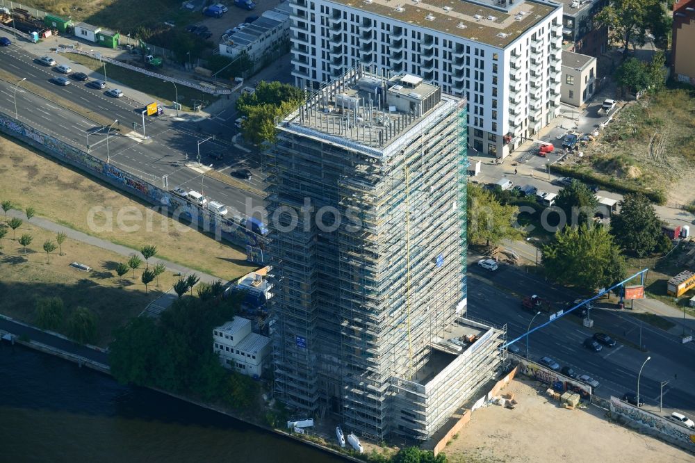 Aerial image Berlin - Construction site of Project Living Levels at Muhlenstrasse on the banks of the River Spree in Berlin - Friedrichshain. On the grounds of the Berlin Wall border strip at the EastSideGallery, the company Living Bauhaus is building a futuristic high-rise residential. The real estate service company City & Home GmbH manages the available apartments