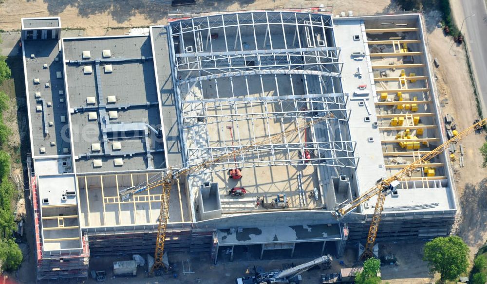 Aerial photograph Potsdam - Blick auf die Baustelle der Mehrzweck-Sporthalle am Olympia-Stützpunkt Luftschiffhafen im Südwesten Potsdams. Die Landeshauptstadt baut im Rahmen des Konjunkturpaket II mit ihrer stadteigene Unternehmensholding Pro Potsdam die 17 Millionen Euro teuren Mehrzweckhalle. Künftig werden dort maximal 2700 Zuschauer auch internationale Sportwettkämpfe verfolgen können. Im Stützpunkt trainieren unter an deren die Fußballerinnen des FFC Turbine Potsdam sowie die zur Weltspitze zählenden Kanuten des OSC Potsdam. Bislang fehlte in der Stadt eine wettkampftaugliche Halle. Die Bauausführung erfolgt durch die ANES Bauausführungen Berlin GmbH. View the construction site of the multi-purpose sports hall at the Olympic base airship base in the southwest of Potsdam.