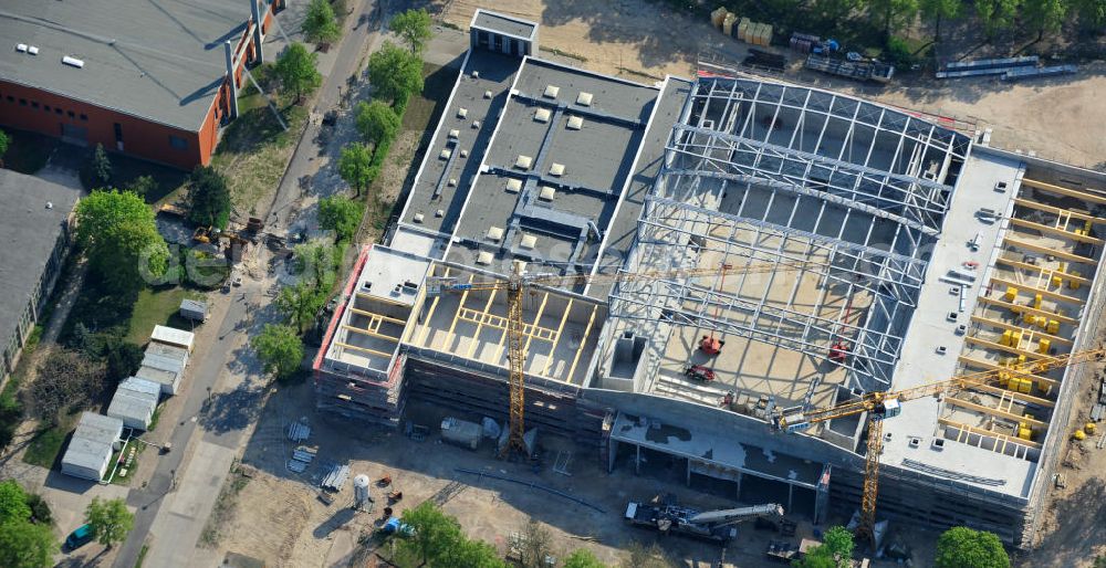 Aerial image Potsdam - Blick auf die Baustelle der Mehrzweck-Sporthalle am Olympia-Stützpunkt Luftschiffhafen im Südwesten Potsdams. Die Landeshauptstadt baut im Rahmen des Konjunkturpaket II mit ihrer stadteigene Unternehmensholding Pro Potsdam die 17 Millionen Euro teuren Mehrzweckhalle. Künftig werden dort maximal 2700 Zuschauer auch internationale Sportwettkämpfe verfolgen können. Im Stützpunkt trainieren unter an deren die Fußballerinnen des FFC Turbine Potsdam sowie die zur Weltspitze zählenden Kanuten des OSC Potsdam. Bislang fehlte in der Stadt eine wettkampftaugliche Halle. Die Bauausführung erfolgt durch die ANES Bauausführungen Berlin GmbH. View the construction site of the multi-purpose sports hall at the Olympic base airship base in the southwest of Potsdam.