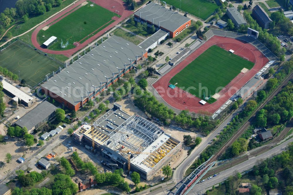 Aerial photograph Potsdam - Blick auf die Baustelle der Mehrzweck-Sporthalle am Olympia-Stützpunkt Luftschiffhafen im Südwesten Potsdams. Die Landeshauptstadt baut im Rahmen des Konjunkturpaket II mit ihrer stadteigene Unternehmensholding Pro Potsdam die 17 Millionen Euro teuren Mehrzweckhalle. Künftig werden dort maximal 2700 Zuschauer auch internationale Sportwettkämpfe verfolgen können. Im Stützpunkt trainieren unter an deren die Fußballerinnen des FFC Turbine Potsdam sowie die zur Weltspitze zählenden Kanuten des OSC Potsdam. Bislang fehlte in der Stadt eine wettkampftaugliche Halle. Die Bauausführung erfolgt durch die ANES Bauausführungen Berlin GmbH. View the construction site of the multi-purpose sports hall at the Olympic base airship base in the southwest of Potsdam.