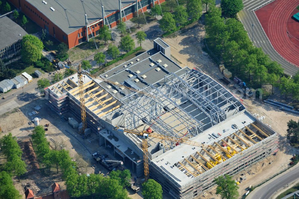 Potsdam from the bird's eye view: Blick auf die Baustelle der Mehrzweck-Sporthalle am Olympia-Stützpunkt Luftschiffhafen im Südwesten Potsdams. Die Landeshauptstadt baut im Rahmen des Konjunkturpaket II mit ihrer stadteigene Unternehmensholding Pro Potsdam die 17 Millionen Euro teuren Mehrzweckhalle. Künftig werden dort maximal 2700 Zuschauer auch internationale Sportwettkämpfe verfolgen können. Im Stützpunkt trainieren unter an deren die Fußballerinnen des FFC Turbine Potsdam sowie die zur Weltspitze zählenden Kanuten des OSC Potsdam. Bislang fehlte in der Stadt eine wettkampftaugliche Halle. Die Bauausführung erfolgt durch die ANES Bauausführungen Berlin GmbH. View the construction site of the multi-purpose sports hall at the Olympic base airship base in the southwest of Potsdam.