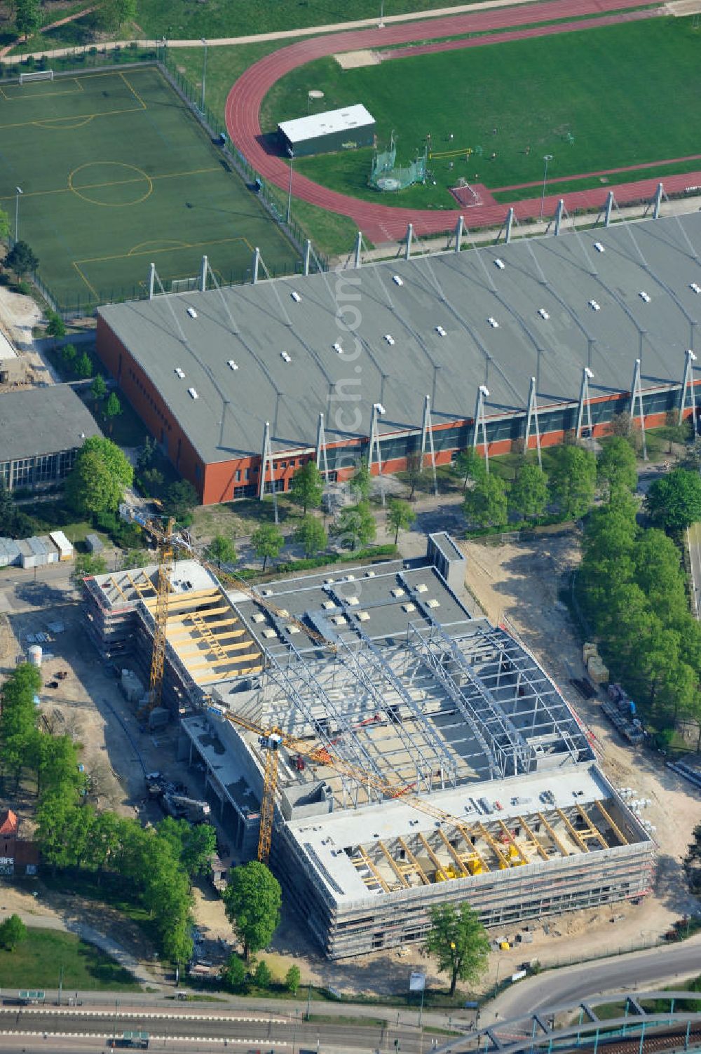 Aerial photograph Potsdam - Blick auf die Baustelle der Mehrzweck-Sporthalle am Olympia-Stützpunkt Luftschiffhafen im Südwesten Potsdams. Die Landeshauptstadt baut im Rahmen des Konjunkturpaket II mit ihrer stadteigene Unternehmensholding Pro Potsdam die 17 Millionen Euro teuren Mehrzweckhalle. Künftig werden dort maximal 2700 Zuschauer auch internationale Sportwettkämpfe verfolgen können. Im Stützpunkt trainieren unter an deren die Fußballerinnen des FFC Turbine Potsdam sowie die zur Weltspitze zählenden Kanuten des OSC Potsdam. Bislang fehlte in der Stadt eine wettkampftaugliche Halle. Die Bauausführung erfolgt durch die ANES Bauausführungen Berlin GmbH. View the construction site of the multi-purpose sports hall at the Olympic base airship base in the southwest of Potsdam.