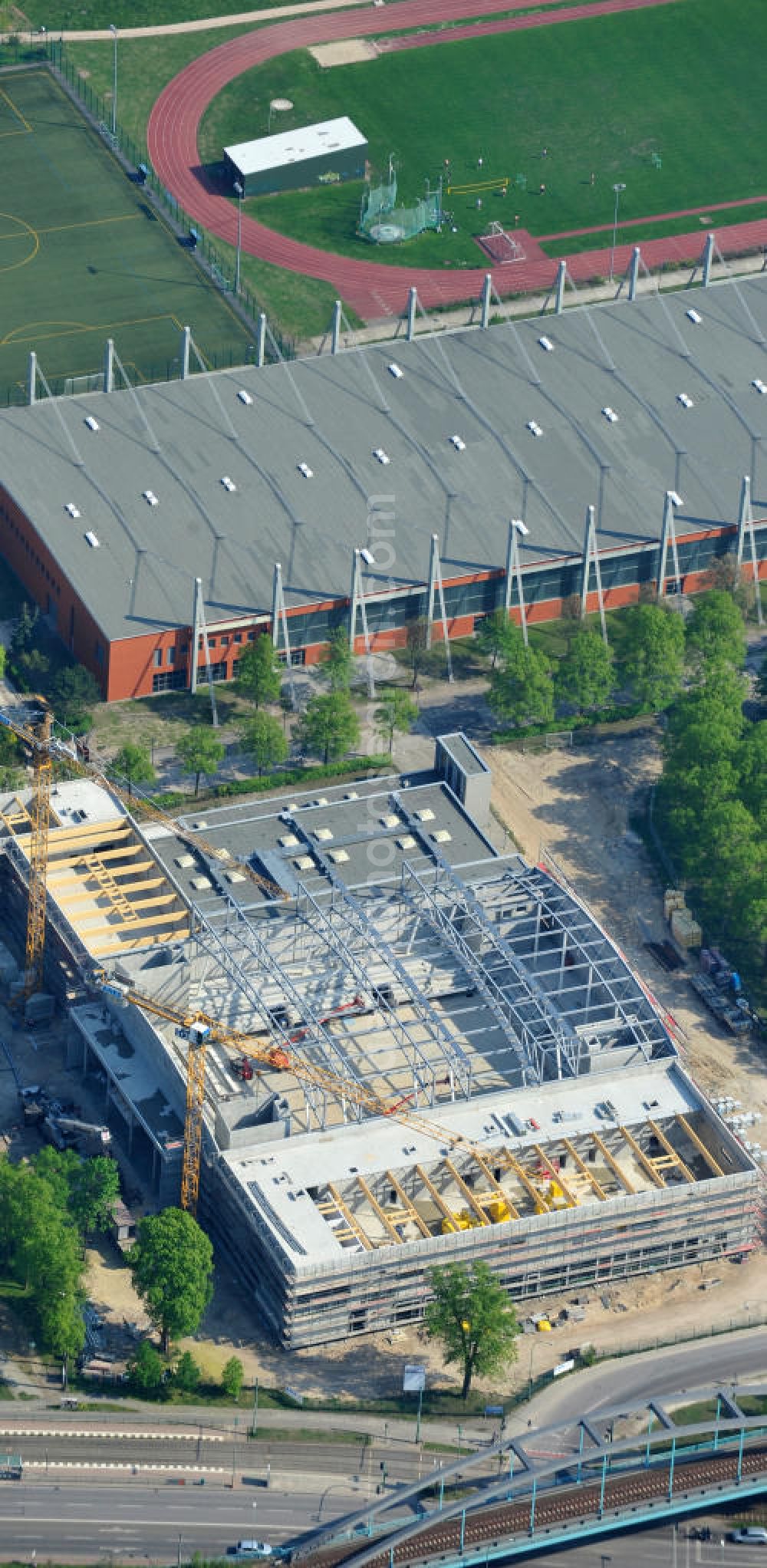 Potsdam from above - Blick auf die Baustelle der Mehrzweck-Sporthalle am Olympia-Stützpunkt Luftschiffhafen im Südwesten Potsdams. Die Landeshauptstadt baut im Rahmen des Konjunkturpaket II mit ihrer stadteigene Unternehmensholding Pro Potsdam die 17 Millionen Euro teuren Mehrzweckhalle. Künftig werden dort maximal 2700 Zuschauer auch internationale Sportwettkämpfe verfolgen können. Im Stützpunkt trainieren unter an deren die Fußballerinnen des FFC Turbine Potsdam sowie die zur Weltspitze zählenden Kanuten des OSC Potsdam. Bislang fehlte in der Stadt eine wettkampftaugliche Halle. Die Bauausführung erfolgt durch die ANES Bauausführungen Berlin GmbH. View the construction site of the multi-purpose sports hall at the Olympic base airship base in the southwest of Potsdam.