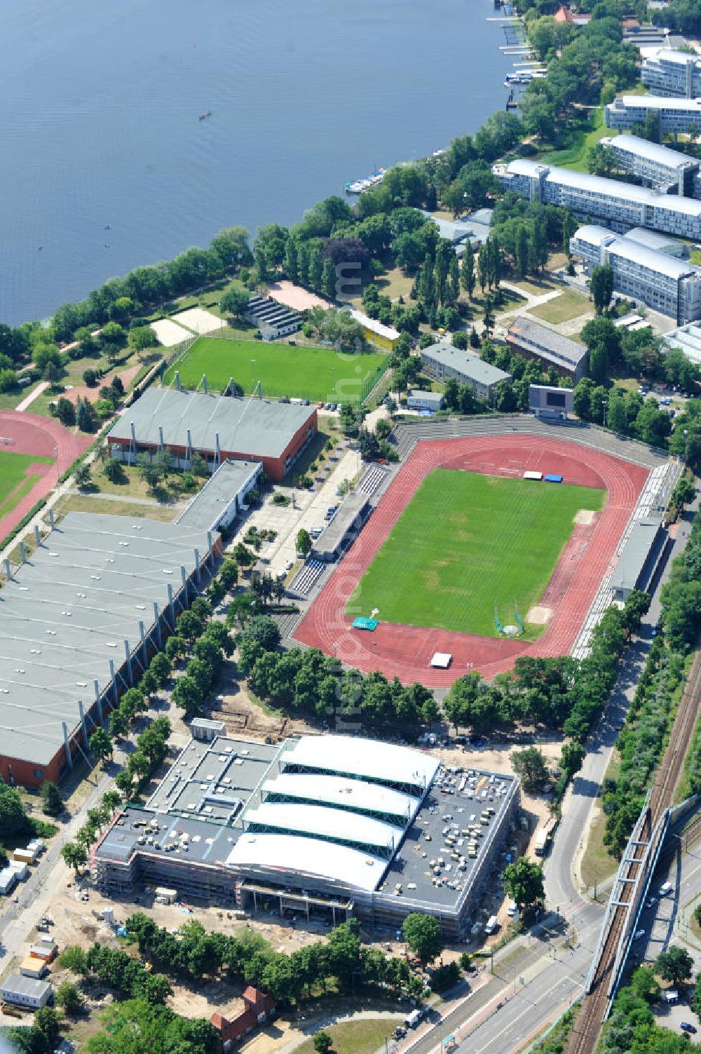 Aerial image Potsdam - Blick auf die Baustelle der Mehrzweck-Sporthalle am Olympia-Stützpunkt Luftschiffhafen im Südwesten Potsdams. Die Landeshauptstadt baut im Rahmen des Konjunkturpaket II mit ihrer stadteigene Unternehmensholding Pro Potsdam die 17 Millionen Euro teuren Mehrzweckhalle. Künftig werden dort maximal 2700 Zuschauer auch internationale Sportwettkämpfe verfolgen können. Im Stützpunkt trainieren unter an deren die Fußballerinnen des FFC Turbine Potsdam sowie die zur Weltspitze zählenden Kanuten des OSC Potsdam. Bislang fehlte in der Stadt eine wettkampftaugliche Halle. Die Bauausführung erfolgt durch die ANES Bauausführungen Berlin GmbH. View the construction site of the multi-purpose sports hall at the Olympic base airship base in the southwest of Potsdam.