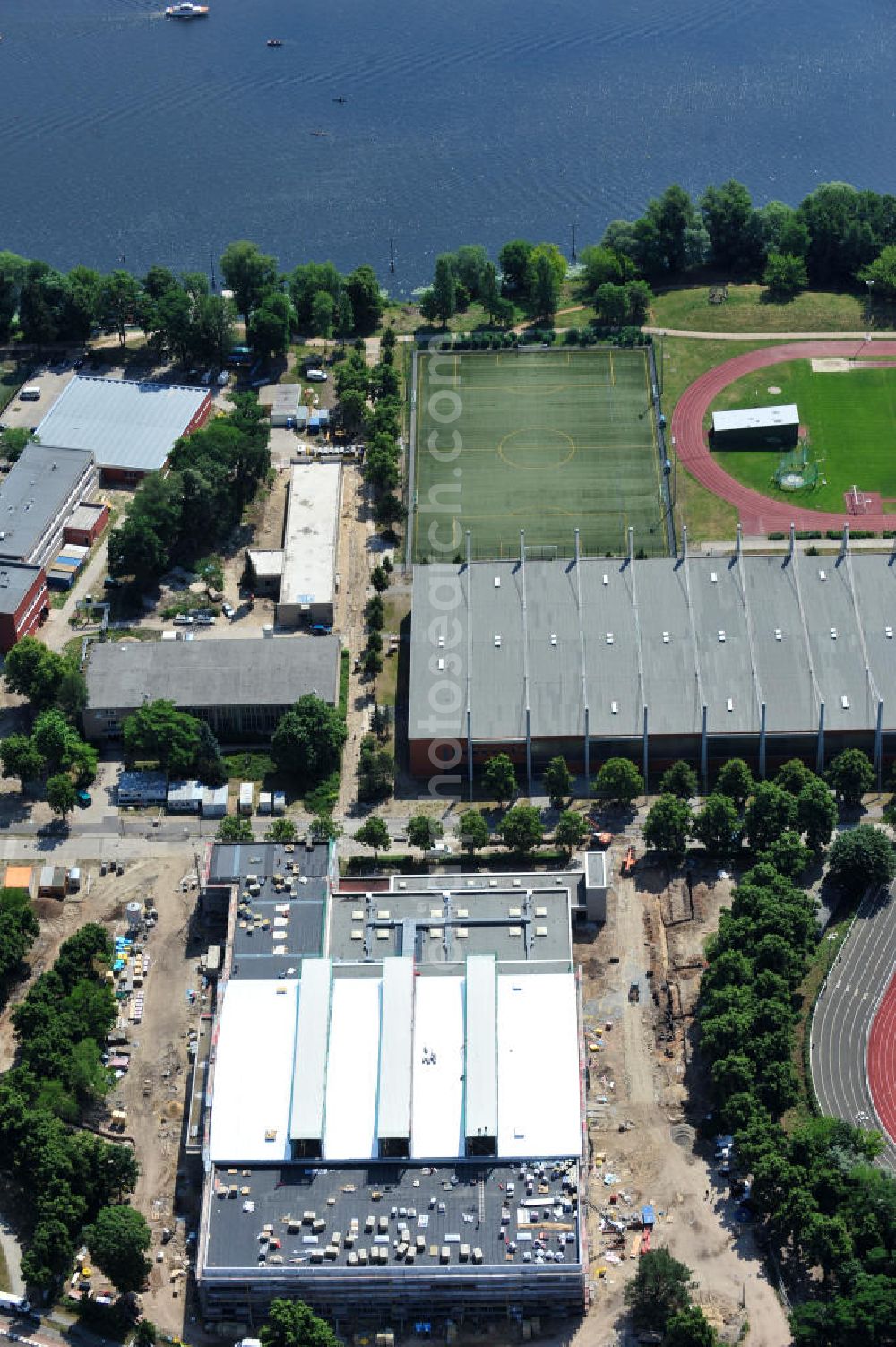 Potsdam from above - Blick auf die Baustelle der Mehrzweck-Sporthalle am Olympia-Stützpunkt Luftschiffhafen im Südwesten Potsdams. Die Landeshauptstadt baut im Rahmen des Konjunkturpaket II mit ihrer stadteigene Unternehmensholding Pro Potsdam die 17 Millionen Euro teuren Mehrzweckhalle. Künftig werden dort maximal 2700 Zuschauer auch internationale Sportwettkämpfe verfolgen können. Im Stützpunkt trainieren unter an deren die Fußballerinnen des FFC Turbine Potsdam sowie die zur Weltspitze zählenden Kanuten des OSC Potsdam. Bislang fehlte in der Stadt eine wettkampftaugliche Halle. Die Bauausführung erfolgt durch die ANES Bauausführungen Berlin GmbH. View the construction site of the multi-purpose sports hall at the Olympic base airship base in the southwest of Potsdam.