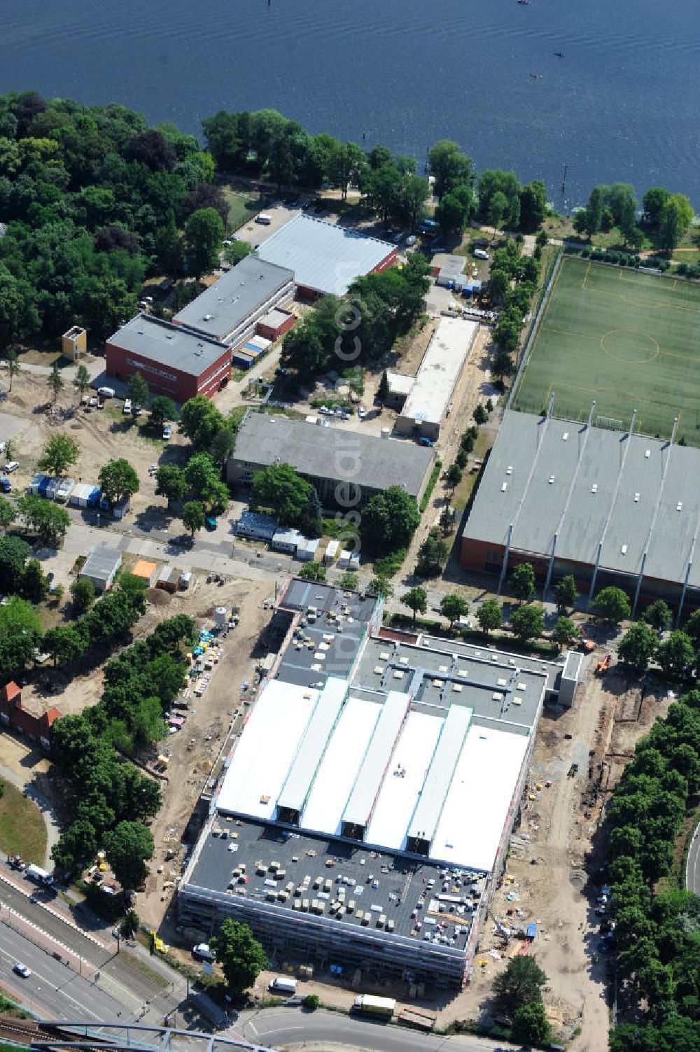 Potsdam from the bird's eye view: Blick auf die Baustelle der Mehrzweck-Sporthalle am Olympia-Stützpunkt Luftschiffhafen im Südwesten Potsdams. Die Landeshauptstadt baut im Rahmen des Konjunkturpaket II mit ihrer stadteigene Unternehmensholding Pro Potsdam die 17 Millionen Euro teuren Mehrzweckhalle. Künftig werden dort maximal 2700 Zuschauer auch internationale Sportwettkämpfe verfolgen können. Im Stützpunkt trainieren unter an deren die Fußballerinnen des FFC Turbine Potsdam sowie die zur Weltspitze zählenden Kanuten des OSC Potsdam. Bislang fehlte in der Stadt eine wettkampftaugliche Halle. Die Bauausführung erfolgt durch die ANES Bauausführungen Berlin GmbH. View the construction site of the multi-purpose sports hall at the Olympic base airship base in the southwest of Potsdam.