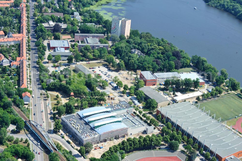 Potsdam from the bird's eye view: Blick auf die Baustelle der Mehrzweck-Sporthalle am Olympia-Stützpunkt Luftschiffhafen im Südwesten Potsdams. Die Landeshauptstadt baut im Rahmen des Konjunkturpaket II mit ihrer stadteigene Unternehmensholding Pro Potsdam die 17 Millionen Euro teuren Mehrzweckhalle. Künftig werden dort maximal 2700 Zuschauer auch internationale Sportwettkämpfe verfolgen können. Im Stützpunkt trainieren unter an deren die Fußballerinnen des FFC Turbine Potsdam sowie die zur Weltspitze zählenden Kanuten des OSC Potsdam. Bislang fehlte in der Stadt eine wettkampftaugliche Halle. Die Bauausführung erfolgt durch die ANES Bauausführungen Berlin GmbH. View the construction site of the multi-purpose sports hall at the Olympic base airship base in the southwest of Potsdam.