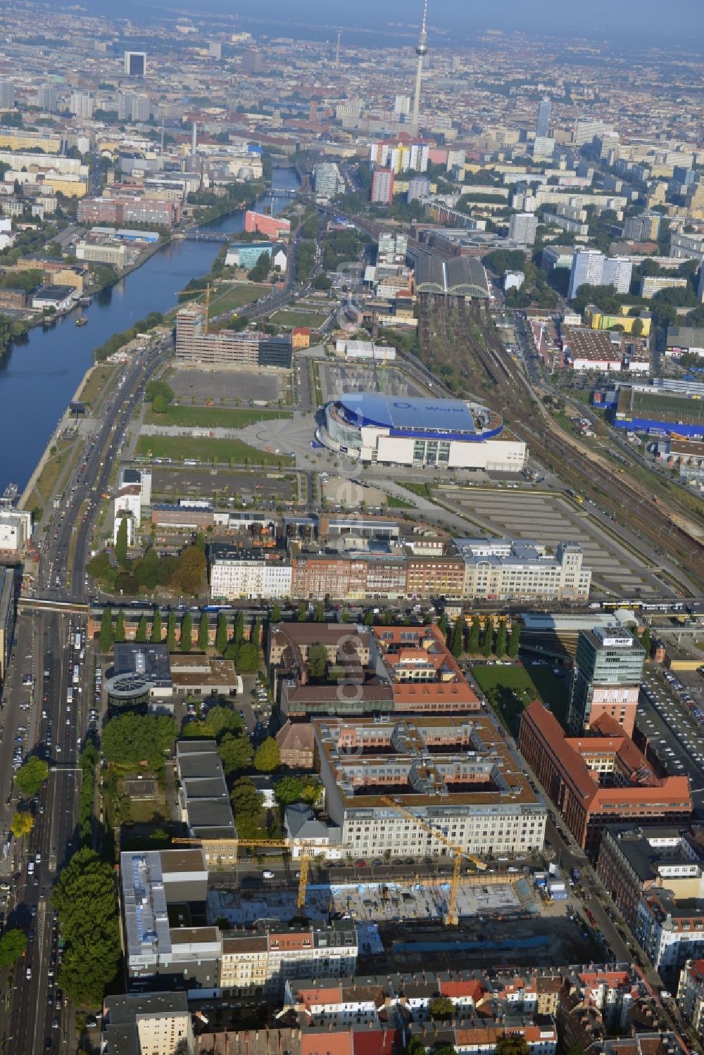 Aerial photograph Berlin - Look at the construction site of the new building of a residential house with condominiums on the Oberbaum City in the district Friedrichshain in Berlin. It is a project of the AccoNarva Engineering Ltd. The bodyshell has been commissioned by the ANES Construction Work Berlin GmbH