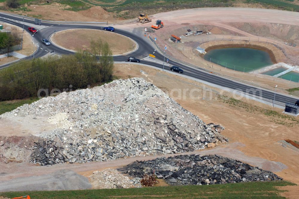 Aerial image Eisenach - Blick auf ein Regenrückhaltebecken, Kreisverkehr und altes, aufgeschütteter Strassenbelag im Nordteil der Baustelle Ausfahrt / Anschlussstelle Eisenach-West der A4. Der Neubau ist Teil des Projekt Nordverlegung / Umfahrung Hörselberge der Autobahn E40 / A4 in Thüringen bei Eisenach. Durchgeführt werden die im Zuge dieses Projektes notwendigen Arbeiten unter an derem von den Mitarbeitern der Niederlassung Weimar der EUROVIA Verkehrsbau Union sowie der Niederlassungen Abbruch und Erdbau, Betonstraßenbau, Ingenieurbau und TECO Schallschutz der EUROVIA Beton sowie der DEGES.