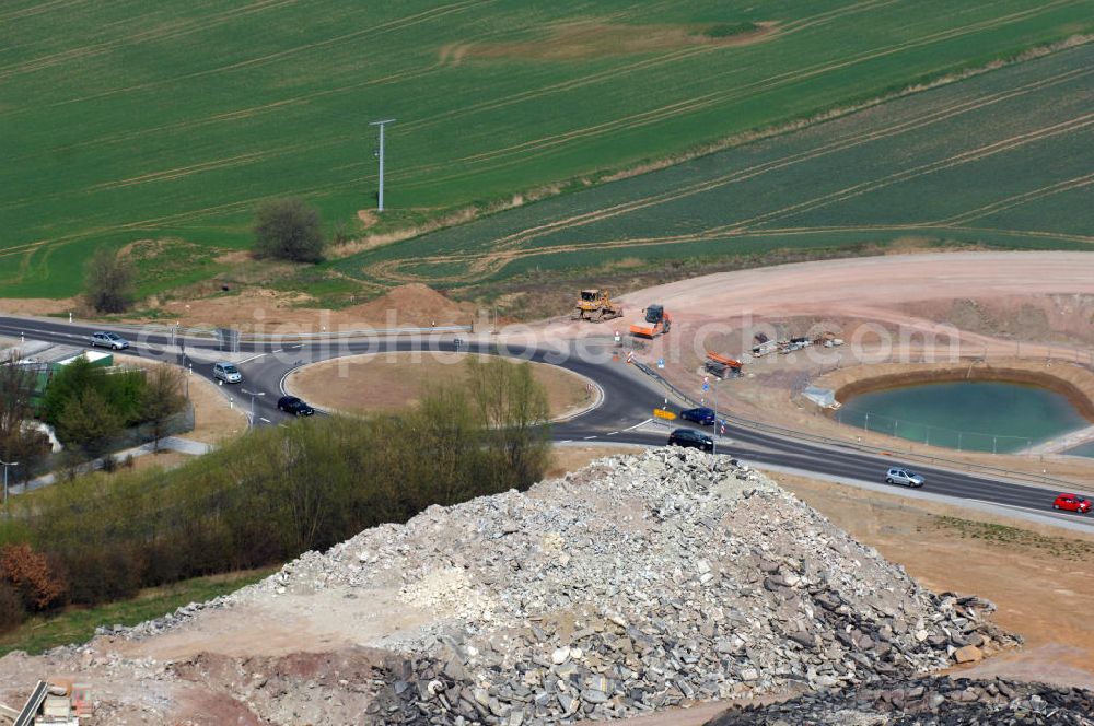 Aerial photograph Eisenach - Blick auf ein Regenrückhaltebecken, Kreisverkehr und altes, aufgeschütteter Strassenbelag im Nordteil der Baustelle Ausfahrt / Anschlussstelle Eisenach-West der A4. Der Neubau ist Teil des Projekt Nordverlegung / Umfahrung Hörselberge der Autobahn E40 / A4 in Thüringen bei Eisenach. Durchgeführt werden die im Zuge dieses Projektes notwendigen Arbeiten unter an derem von den Mitarbeitern der Niederlassung Weimar der EUROVIA Verkehrsbau Union sowie der Niederlassungen Abbruch und Erdbau, Betonstraßenbau, Ingenieurbau und TECO Schallschutz der EUROVIA Beton sowie der DEGES.