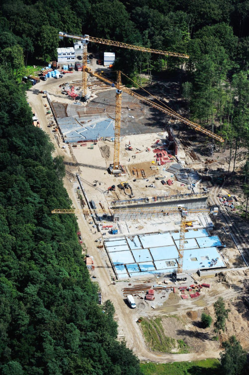 Rostock from above - Blick auf die Baustelle des neuen Darwineum , einem Menschenaffenhaus im Erweiterungsgelände des Rostocker Zoo. Die künftige Bildungs- und Erlebniswelt DARWINEUM mit Menschenaffengehege wird eine Ausstellung zur Evolution des Menschen mit Aquarium, Tropenhalle und einem großen Süßwasserbecken beinhalten. Das Bauprojekt im Barnstorfer Wald soll den Besucherstrom des Zoos erheblich vergrößern. Federführende Unternehmen beim Bau sind die INROS LACKNER AG, Rasbach Architekten und dem Ingenieurbüro Jochen Döhler. Site of the new Darwineum, a primate house in the Rostock Zoo.