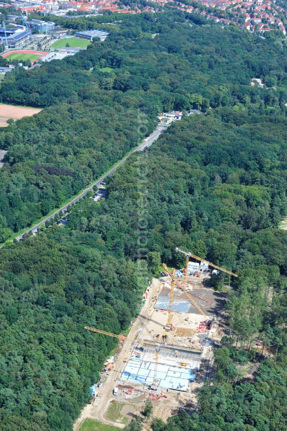 Rostock from the bird's eye view: Blick auf die Baustelle des neuen Darwineum , einem Menschenaffenhaus im Erweiterungsgelände des Rostocker Zoo. Die künftige Bildungs- und Erlebniswelt DARWINEUM mit Menschenaffengehege wird eine Ausstellung zur Evolution des Menschen mit Aquarium, Tropenhalle und einem großen Süßwasserbecken beinhalten. Das Bauprojekt im Barnstorfer Wald soll den Besucherstrom des Zoos erheblich vergrößern. Federführende Unternehmen beim Bau sind die INROS LACKNER AG, Rasbach Architekten und dem Ingenieurbüro Jochen Döhler. Site of the new Darwineum, a primate house in the Rostock Zoo.