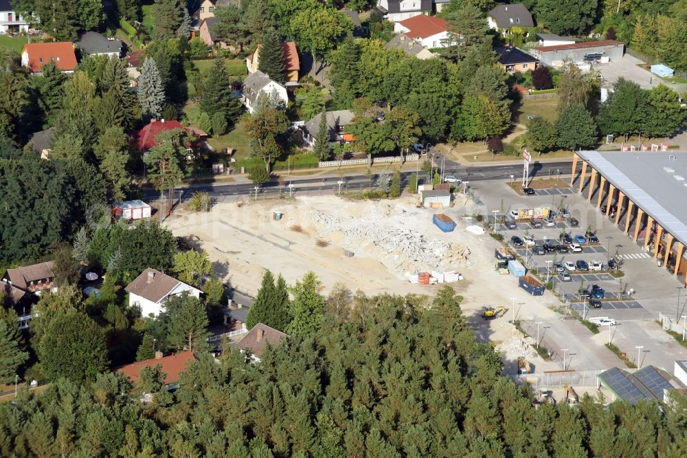 Aerial photograph Hohen Neuendorf - Construction site of a new shopping center and store of the Supermarket REWE in Hohen Neuendorf in the state of Brandenburg. A new shopping facility with stores is being built as part of the regeneration of the shopping center HDZ on Schoenfliesser Strasse. The project is carried out by GVG Projektentwicklungsgesellschaft mbH