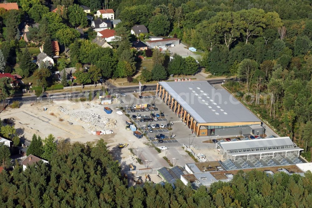 Hohen Neuendorf from above - Construction site of a new shopping center and store of the Supermarket REWE in Hohen Neuendorf in the state of Brandenburg. A new shopping facility with stores is being built as part of the regeneration of the shopping center HDZ on Schoenfliesser Strasse. The project is carried out by GVG Projektentwicklungsgesellschaft mbH