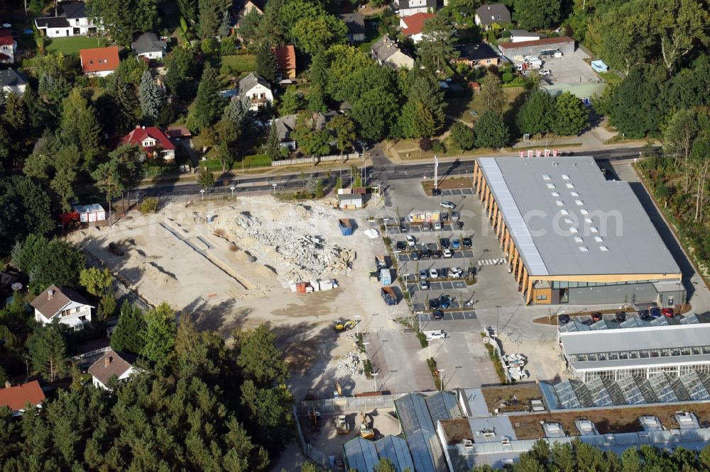 Aerial image Hohen Neuendorf - Construction site of a new shopping center and store of the Supermarket REWE in Hohen Neuendorf in the state of Brandenburg. A new shopping facility with stores is being built as part of the regeneration of the shopping center HDZ on Schoenfliesser Strasse. The project is carried out by GVG Projektentwicklungsgesellschaft mbH