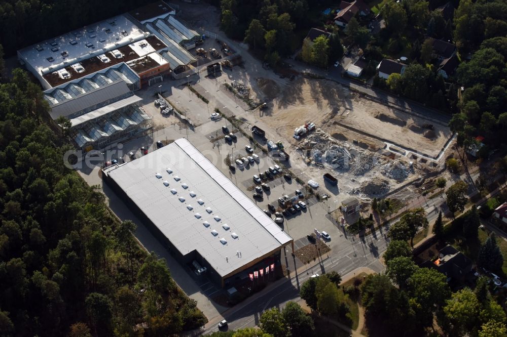 Aerial photograph Hohen Neuendorf - Construction site of a new shopping center and store of the Supermarket REWE in Hohen Neuendorf in the state of Brandenburg. A new shopping facility with stores is being built as part of the regeneration of the shopping center HDZ on Schoenfliesser Strasse. The project is carried out by GVG Projektentwicklungsgesellschaft mbH