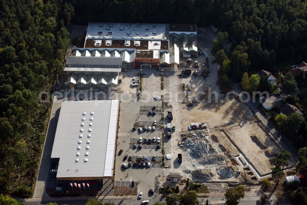 Hohen Neuendorf from above - Construction site of a new shopping center and store of the Supermarket REWE in Hohen Neuendorf in the state of Brandenburg. A new shopping facility with stores is being built as part of the regeneration of the shopping center HDZ on Schoenfliesser Strasse. The project is carried out by GVG Projektentwicklungsgesellschaft mbH