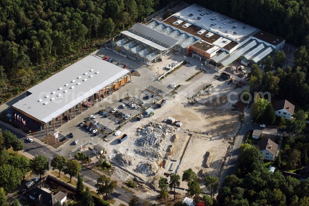 Hohen Neuendorf from the bird's eye view: Construction site of a new shopping center and store of the Supermarket REWE in Hohen Neuendorf in the state of Brandenburg. A new shopping facility with stores is being built as part of the regeneration of the shopping center HDZ on Schoenfliesser Strasse. The project is carried out by GVG Projektentwicklungsgesellschaft mbH