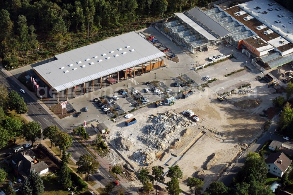 Aerial image Hohen Neuendorf - Construction site of a new shopping center and store of the Supermarket REWE in Hohen Neuendorf in the state of Brandenburg. A new shopping facility with stores is being built as part of the regeneration of the shopping center HDZ on Schoenfliesser Strasse. The project is carried out by GVG Projektentwicklungsgesellschaft mbH